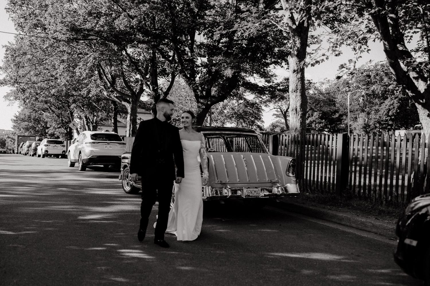 Wedding couple silhouetted against trees in black and white panoramic series.