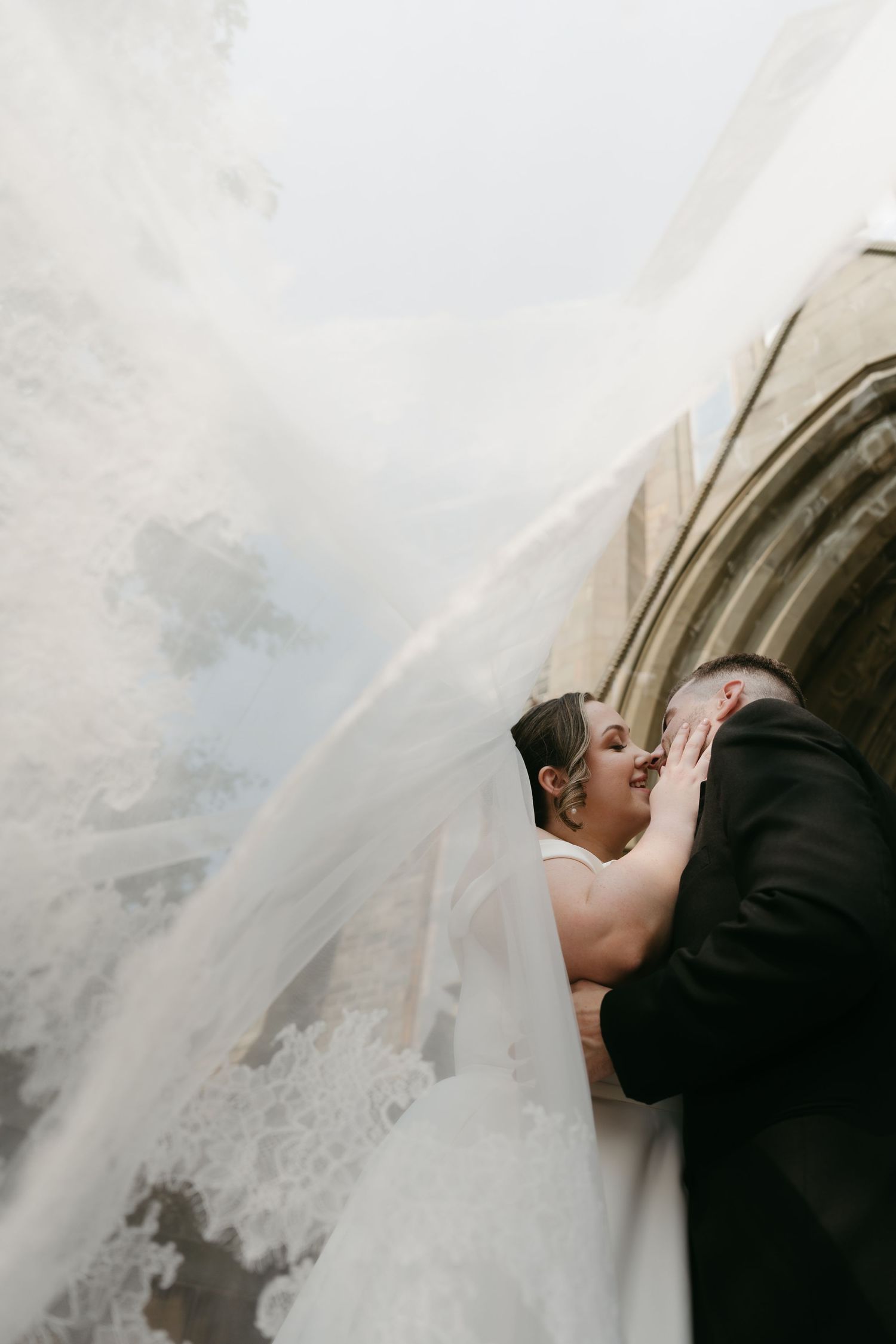 A tender wedding moment photographed against church stone walls.