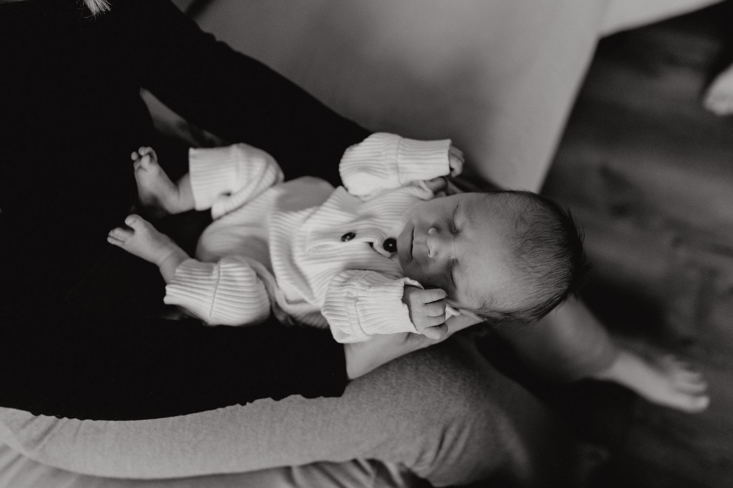 Black and white photograph showing delicate care of a newborn's tiny feet.