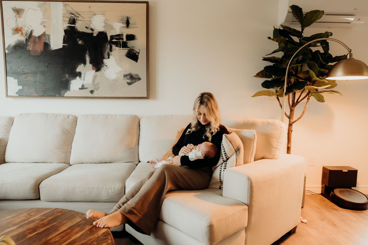 Stylish living space with wall art, fiddle leaf fig, and modern grey furniture.