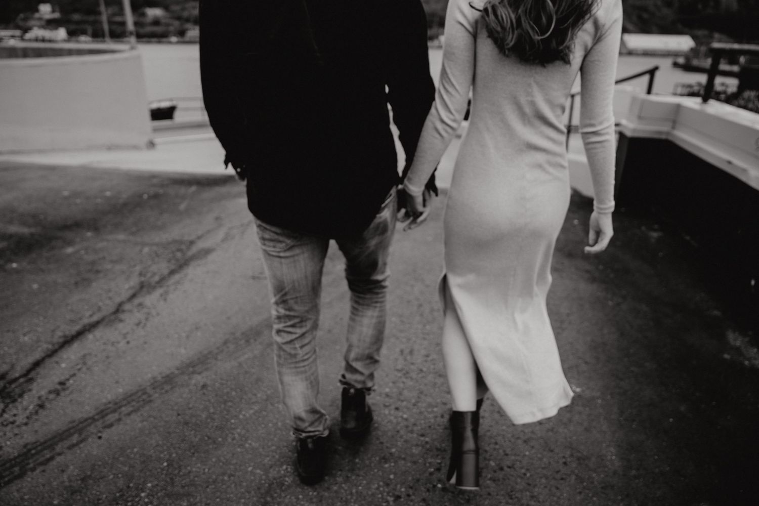 A black and white photo showing a couple walking together, focused on their lower bodies.