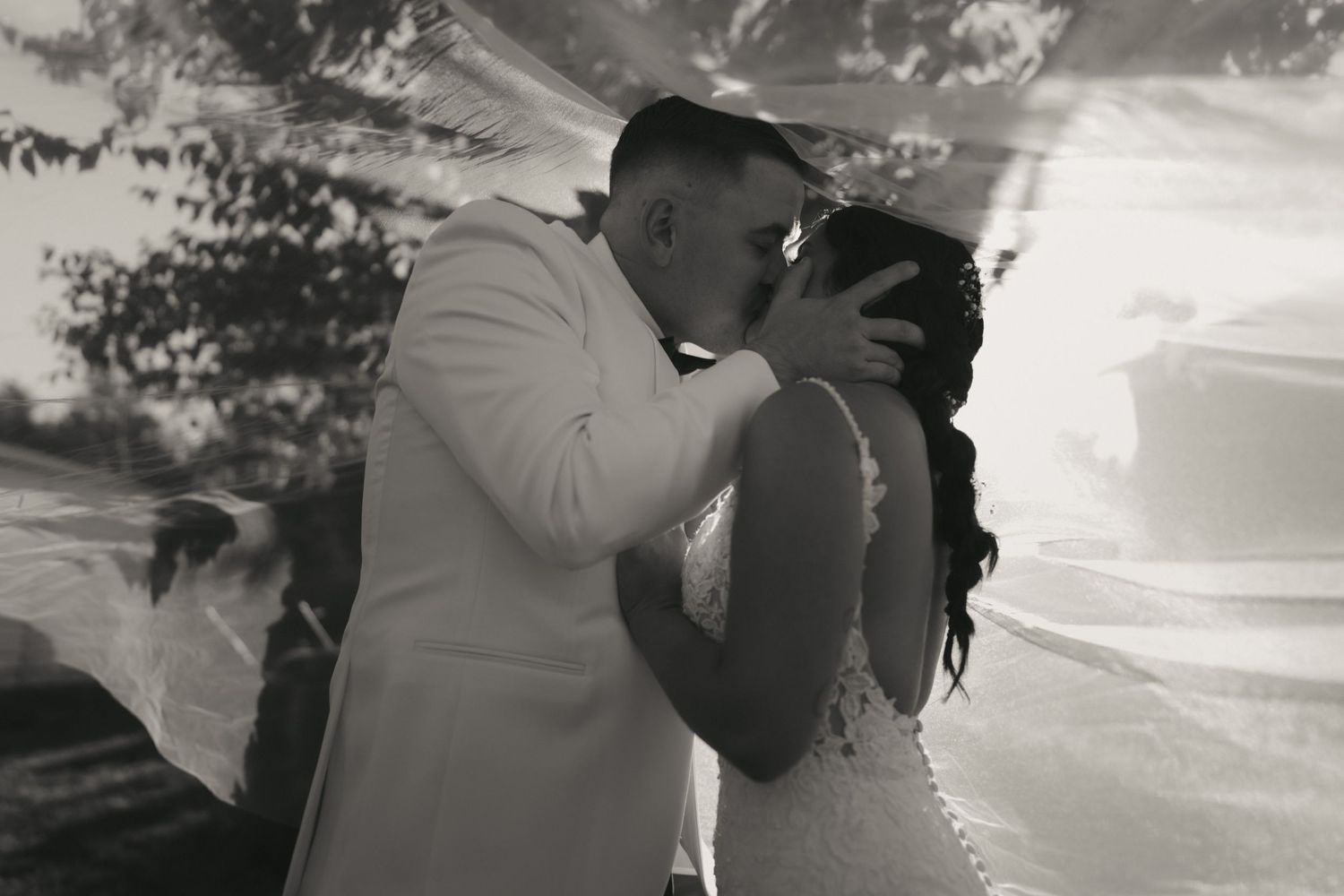 Black and white collage of romantic couple embracing and kissing in various poses during their wedding photoshoot.