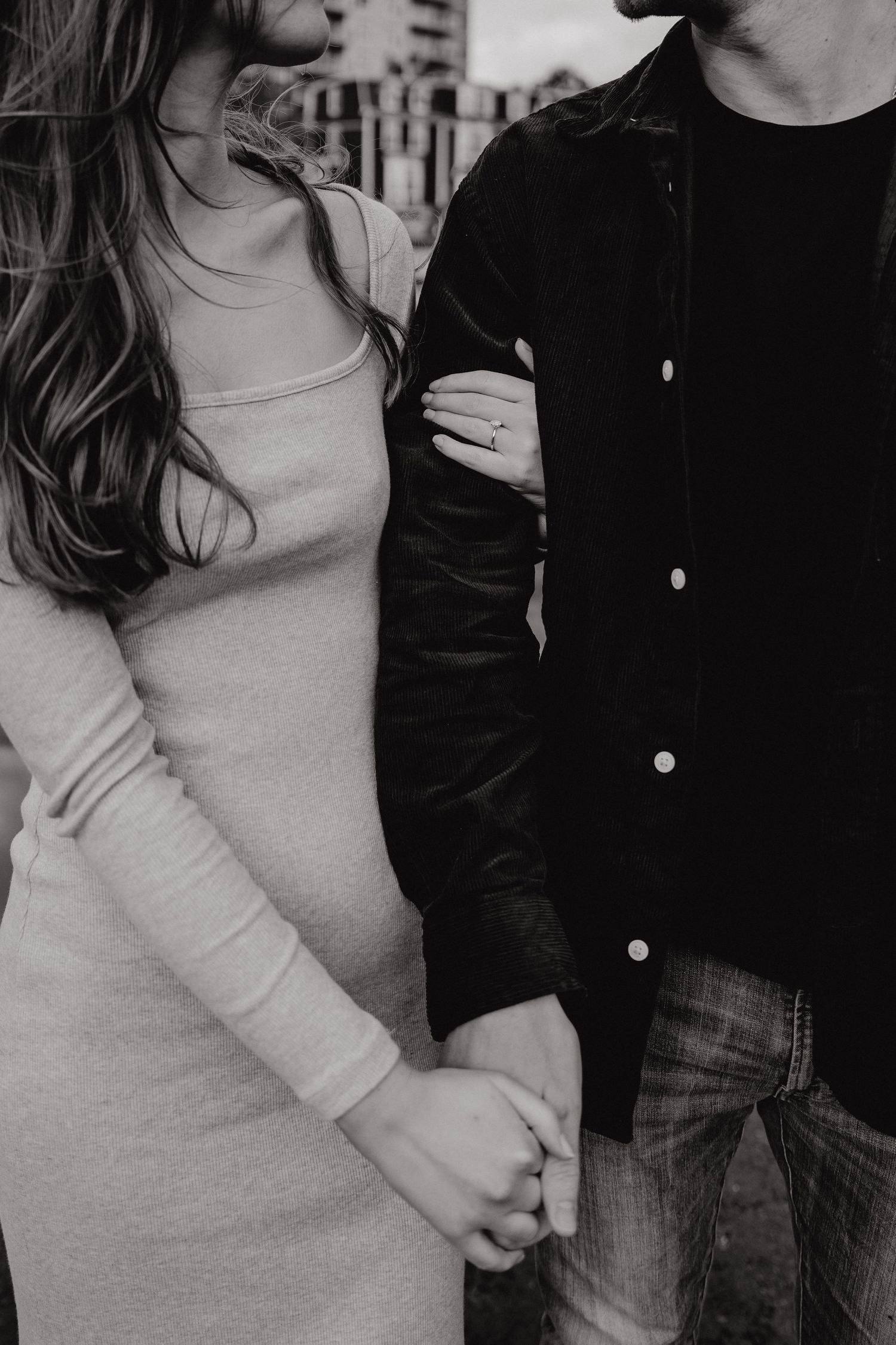 Black and white portrait of a couple in casual wear standing close together.