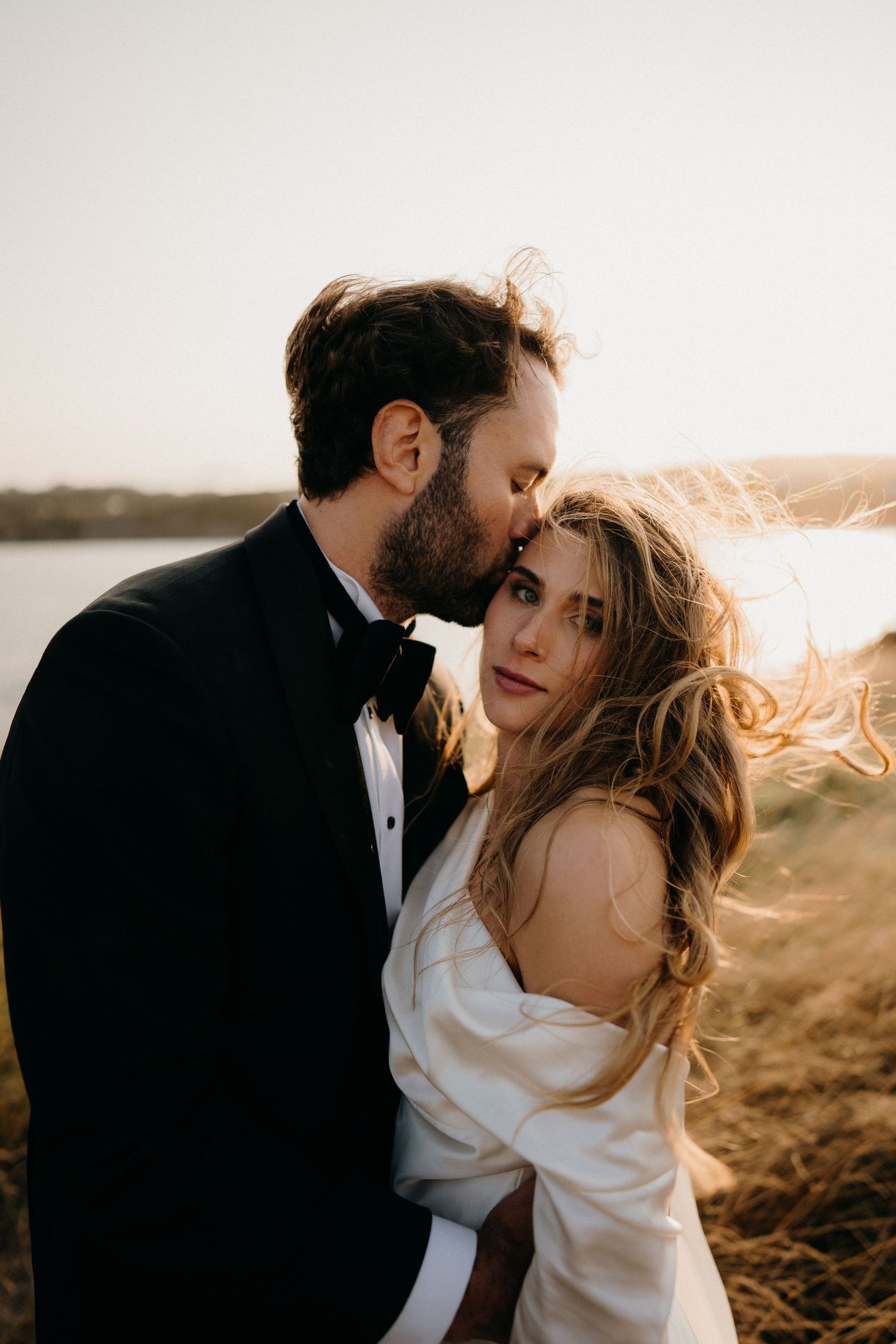 Intimate sunset portrait session on windswept coastal cliffs with dramatic lighting.