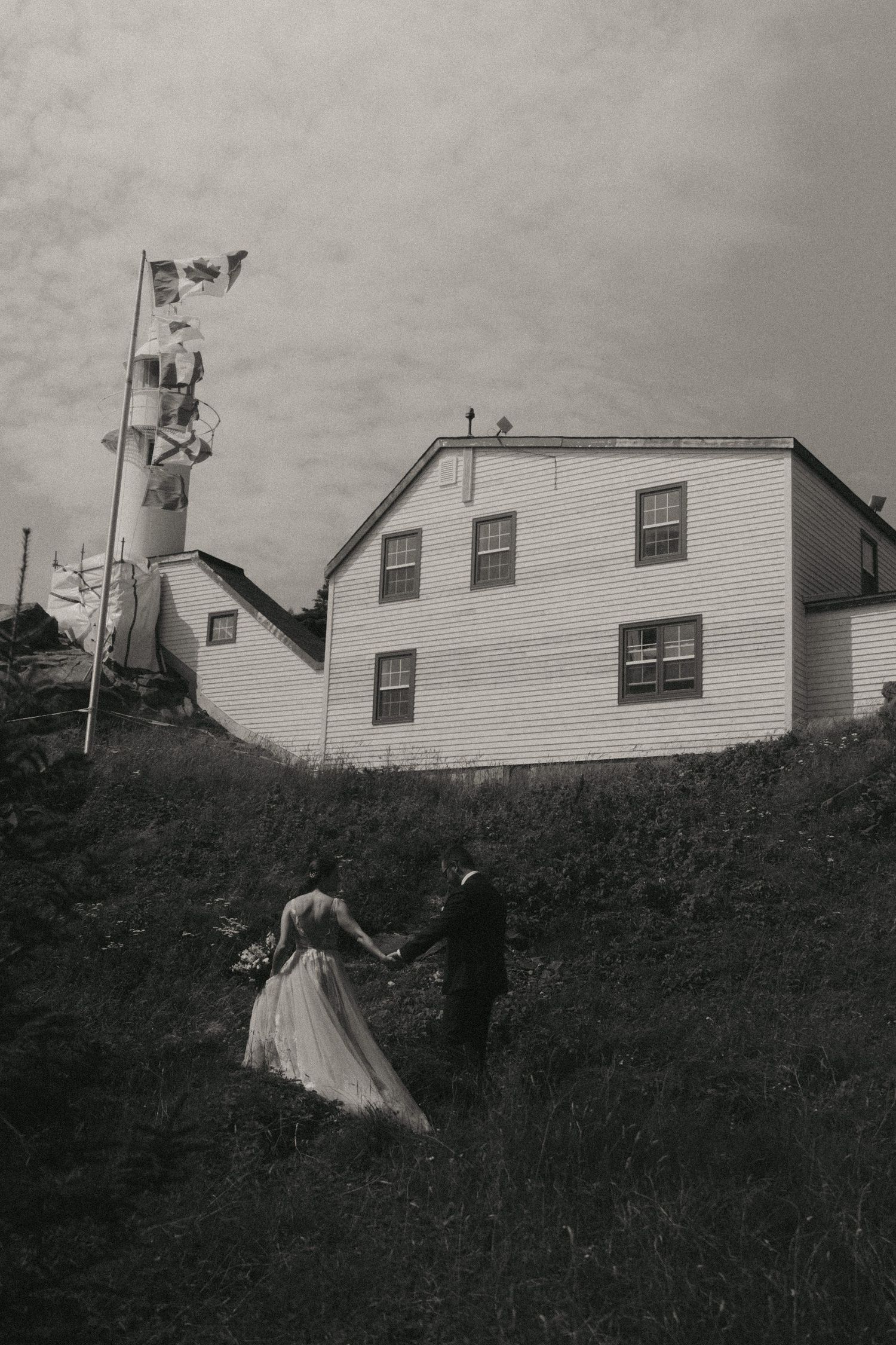 A sequence of black and white photos showing a white house on a hill with laundry sheets fluttering in the wind.