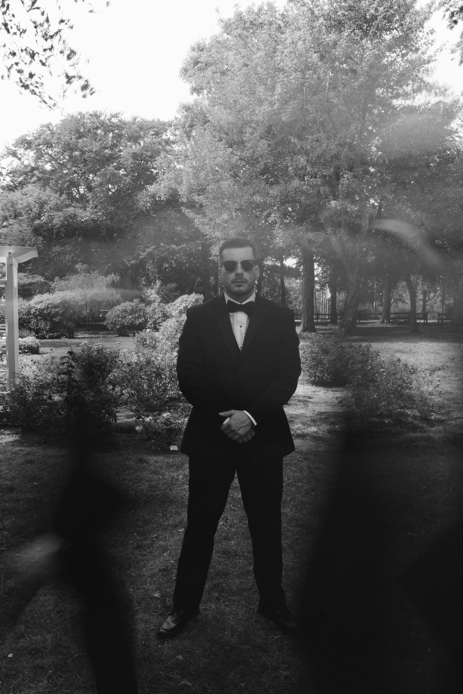 Black and white photo of groomsmen standing in formation outdoors.