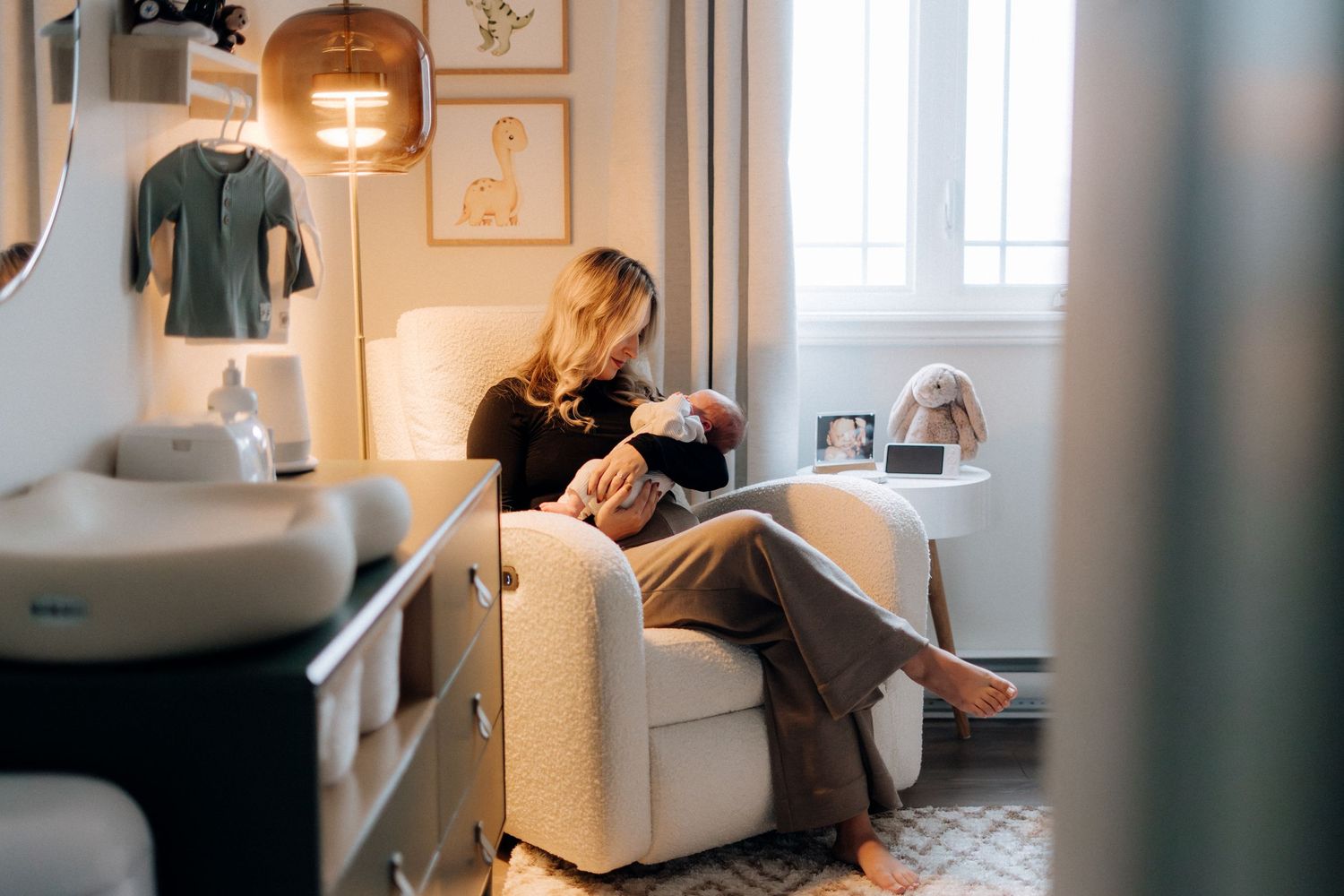 A tender moment with a newborn baby in a warmly lit nursery with modern decor.