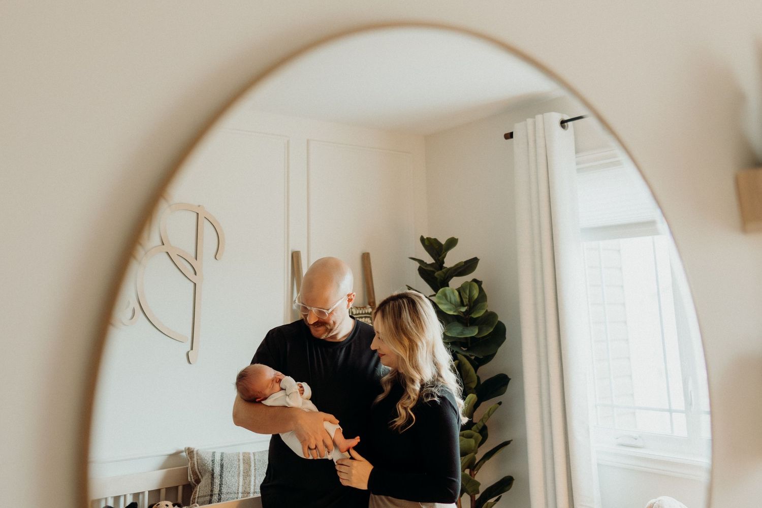 Continuous mirror reflections show tender moments in a modern nursery setting.