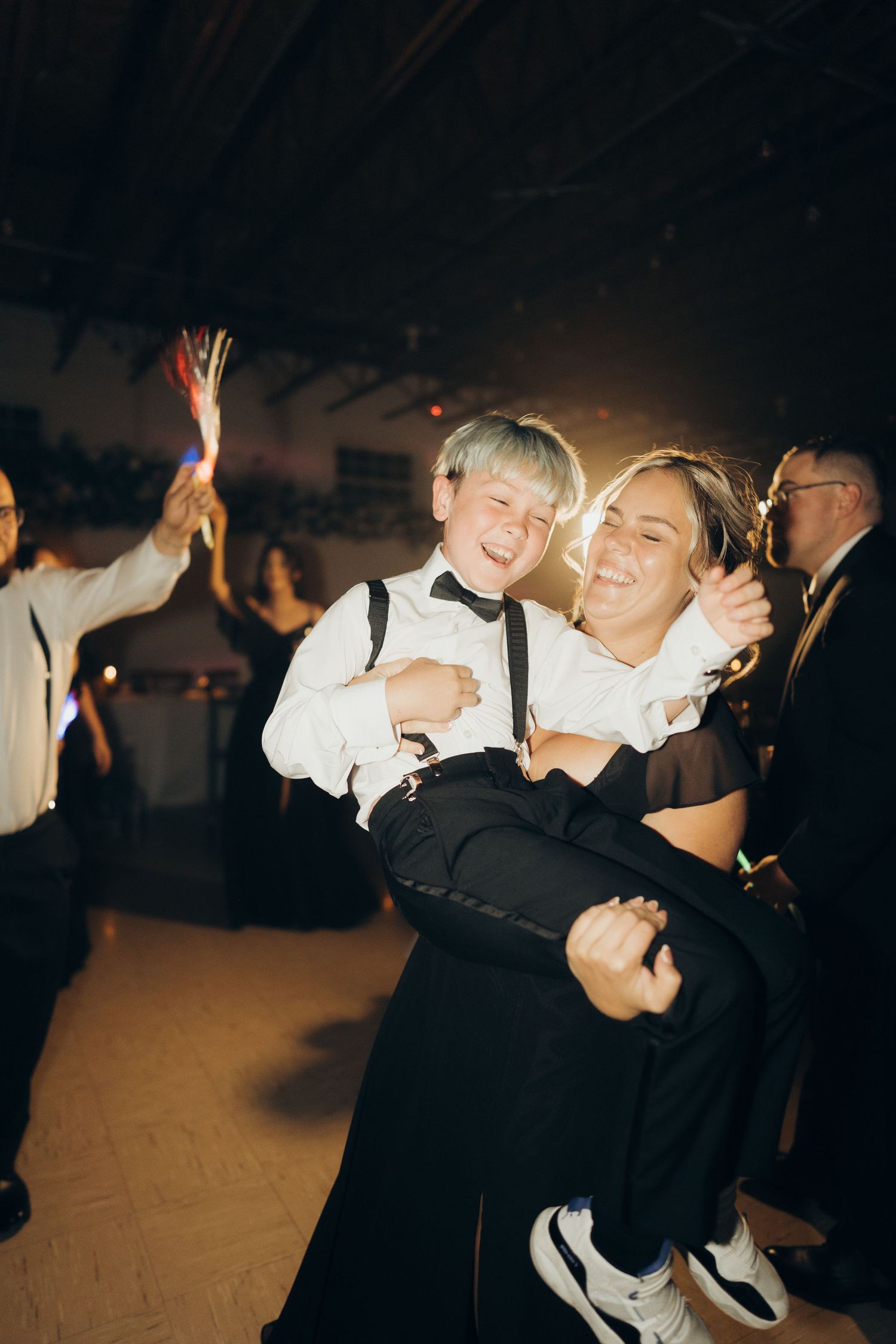 A couple dances together at a formal event in black and white formal attire.