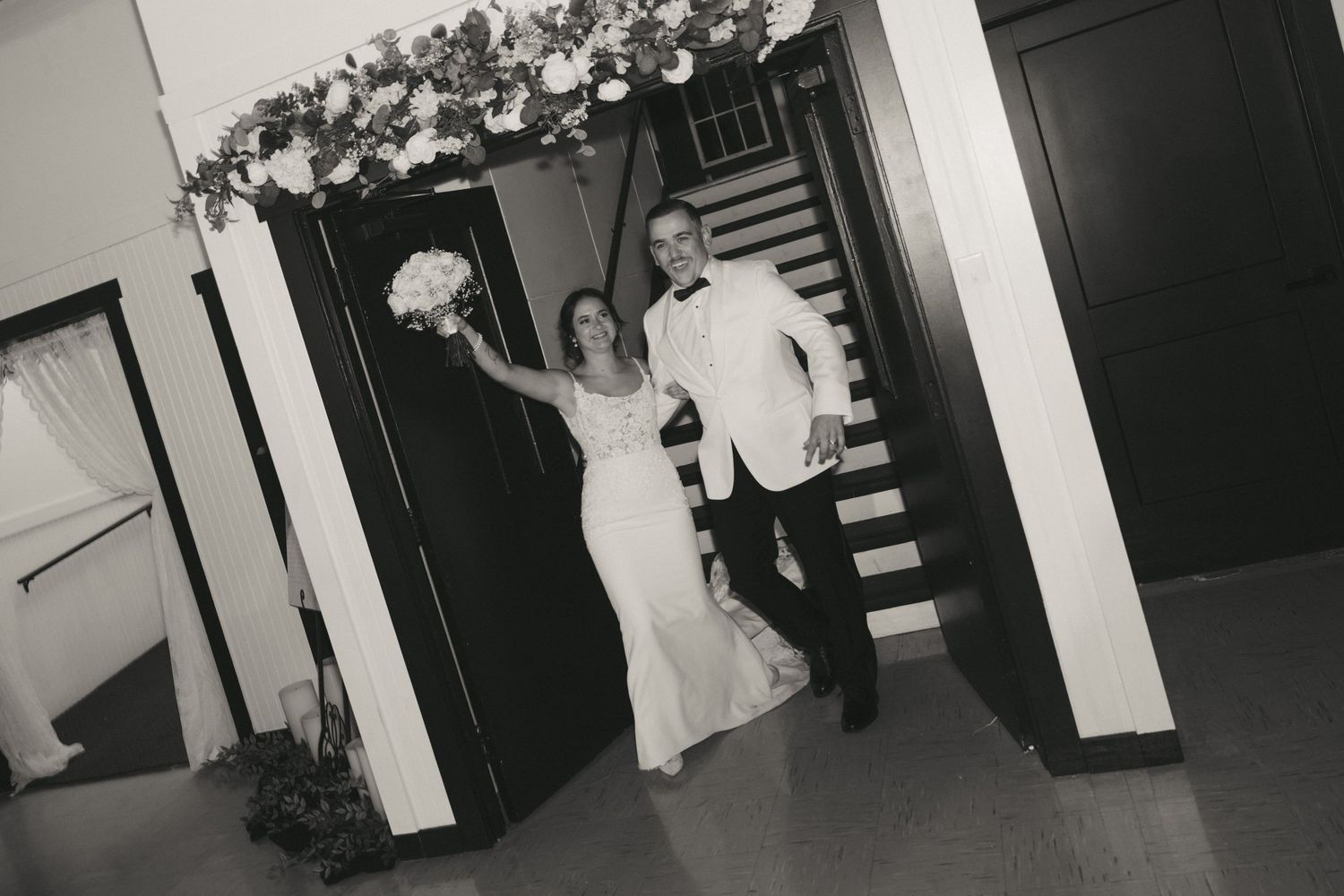 Black and white photograph showing a wedding ceremony with people standing in an ornate church interior.