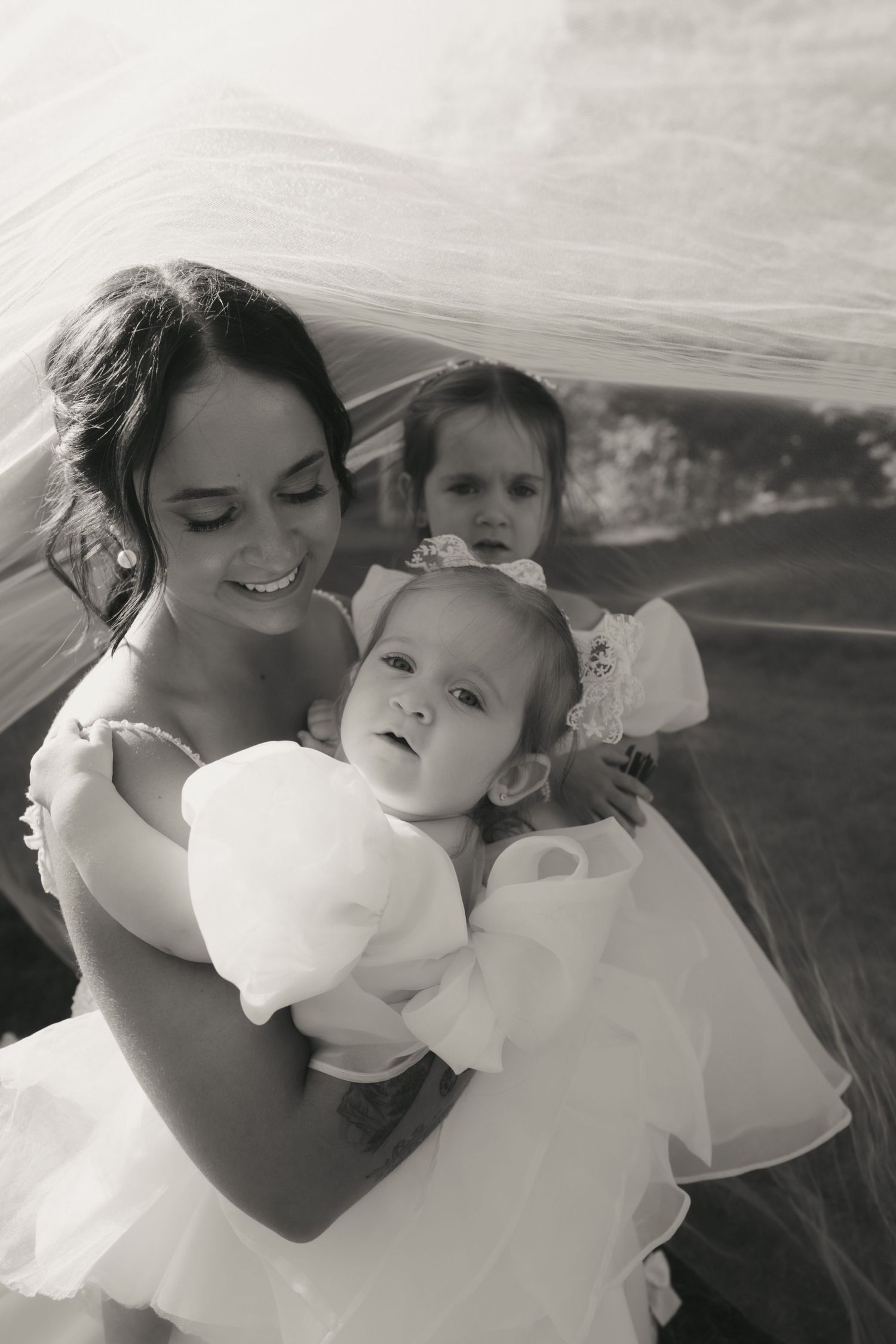 A tender black and white photo series showing a parent and child playfully blowing cotton candy together outdoors.
