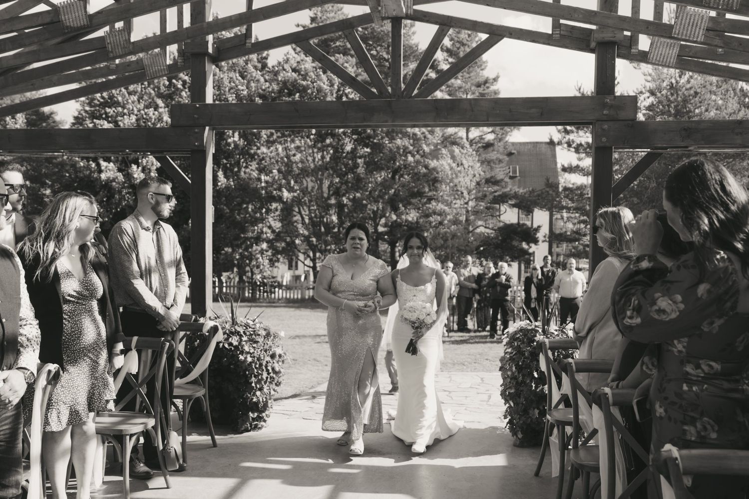 A covered walkway with people walking through a shopping area and market stalls visible on both sides.
