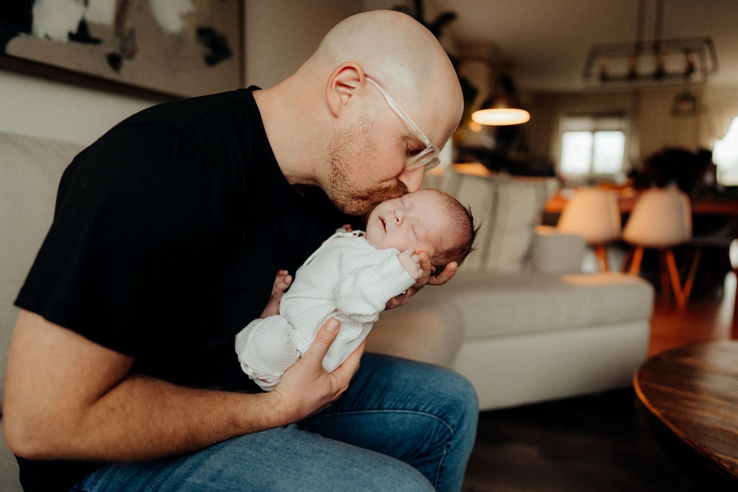 Parents sharing tender moments with their newborn baby in natural home setting.