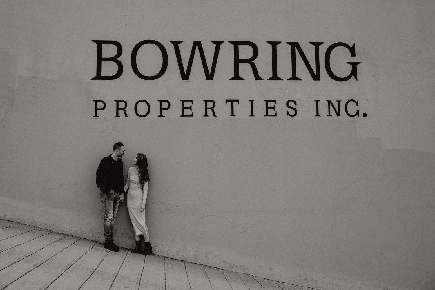 Modern business signage reading Bowring Properties Inc against a clean white wall.