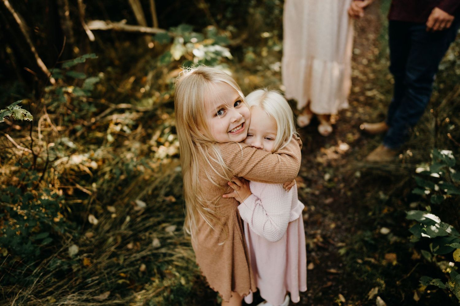 Candid family portraits taken in a serene forest setting during golden hour.