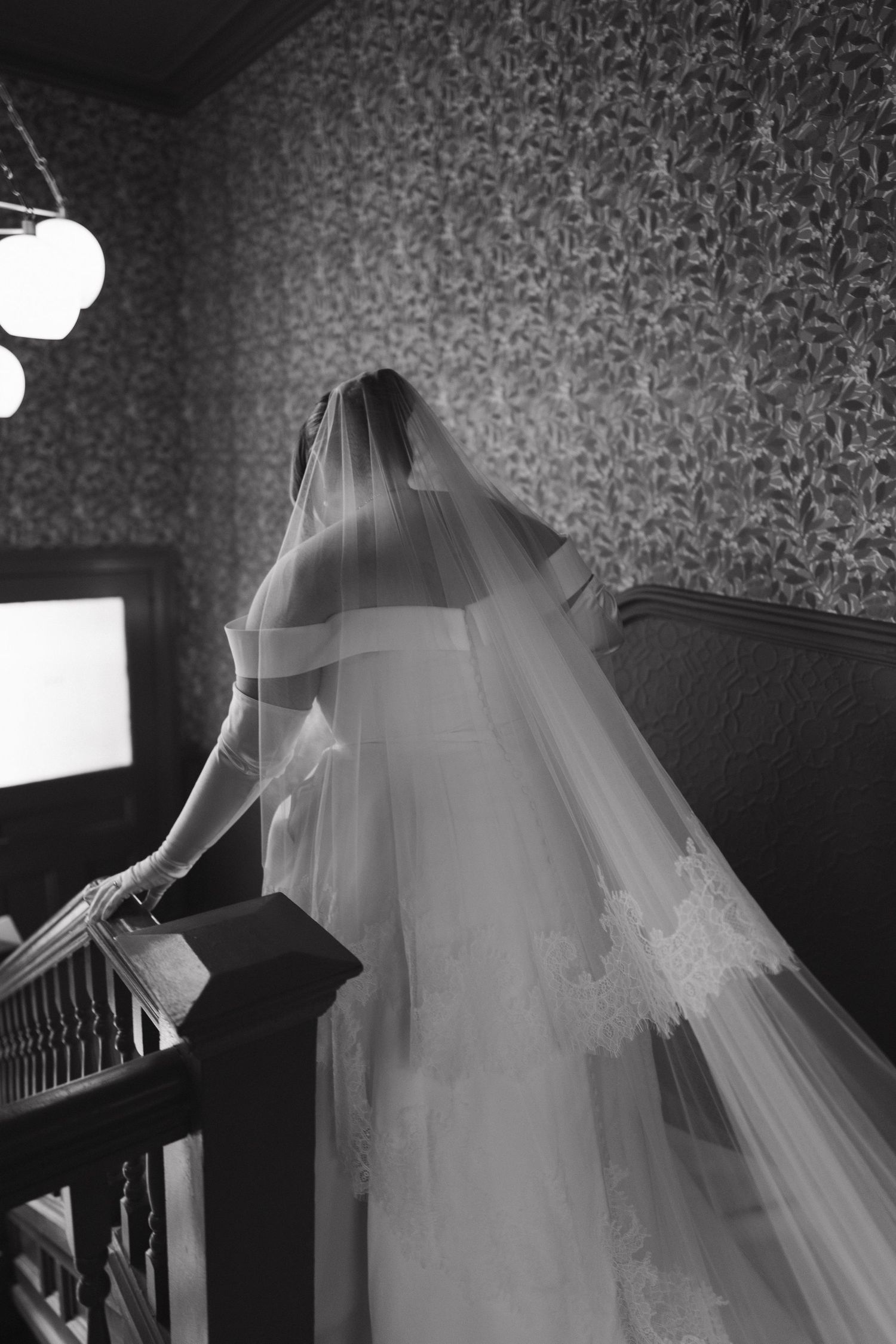 Black and white photos of flowing wedding dress on stairs.
