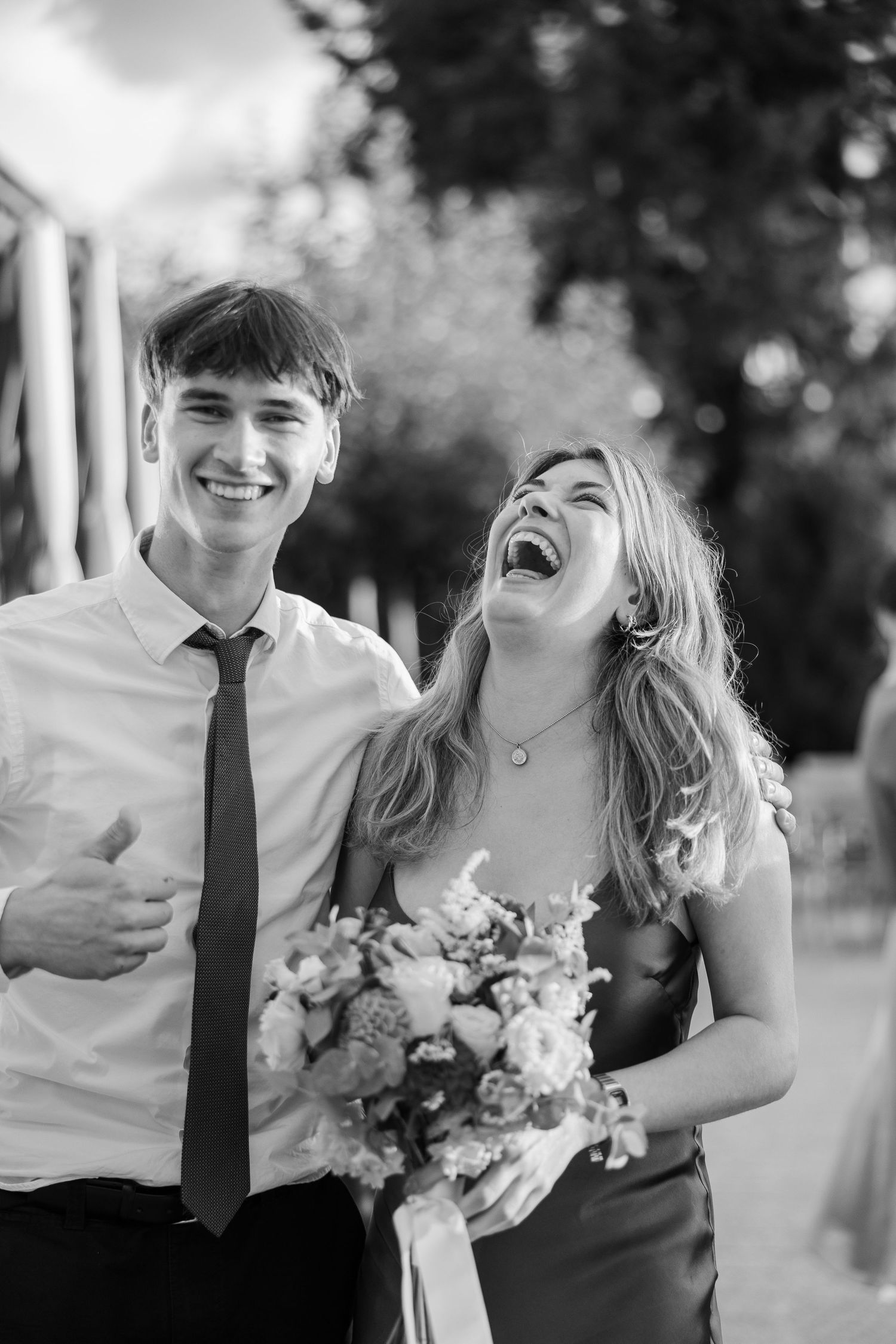 A couple shares joyful laughter together during their outdoor wedding photoshoot - Hochzeitsfotograf Schweiz