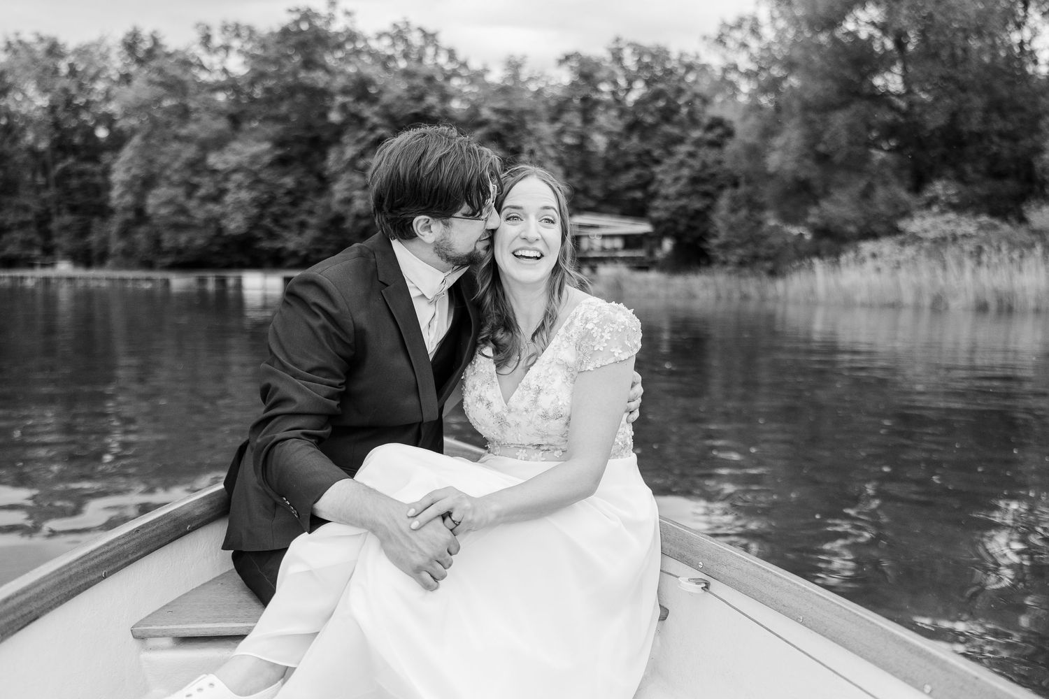 A romantic black and white wedding photo series showing intimate moments by a serene lake.