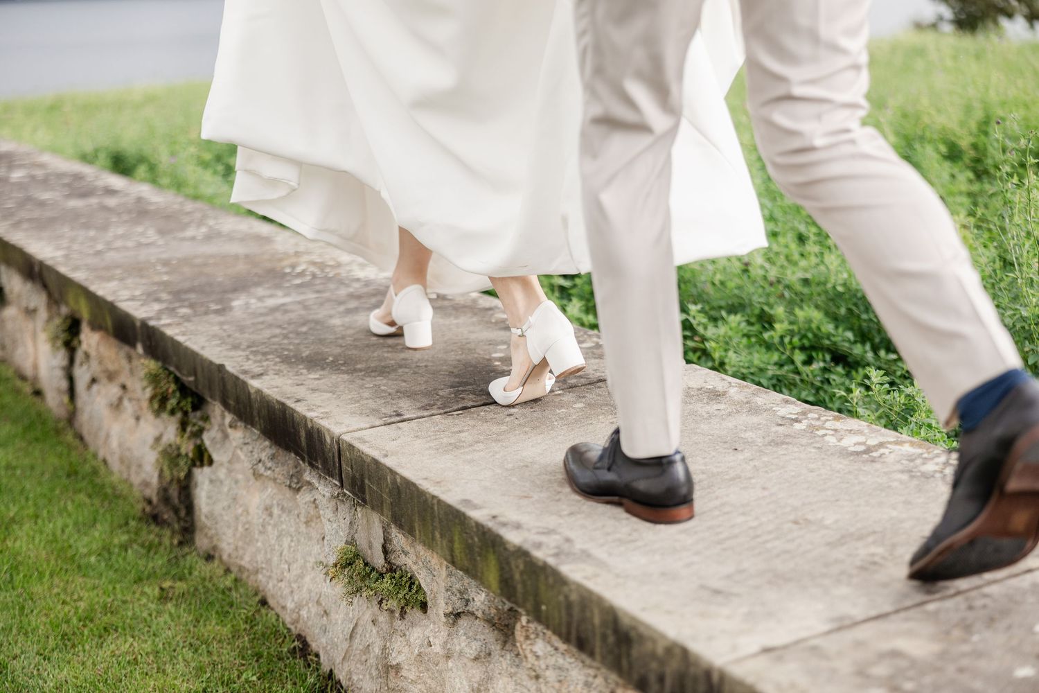 A close-up view of feet walking up concrete steps, showing white pants and brown dress shoes -  Hochzeitsfotograf Zug