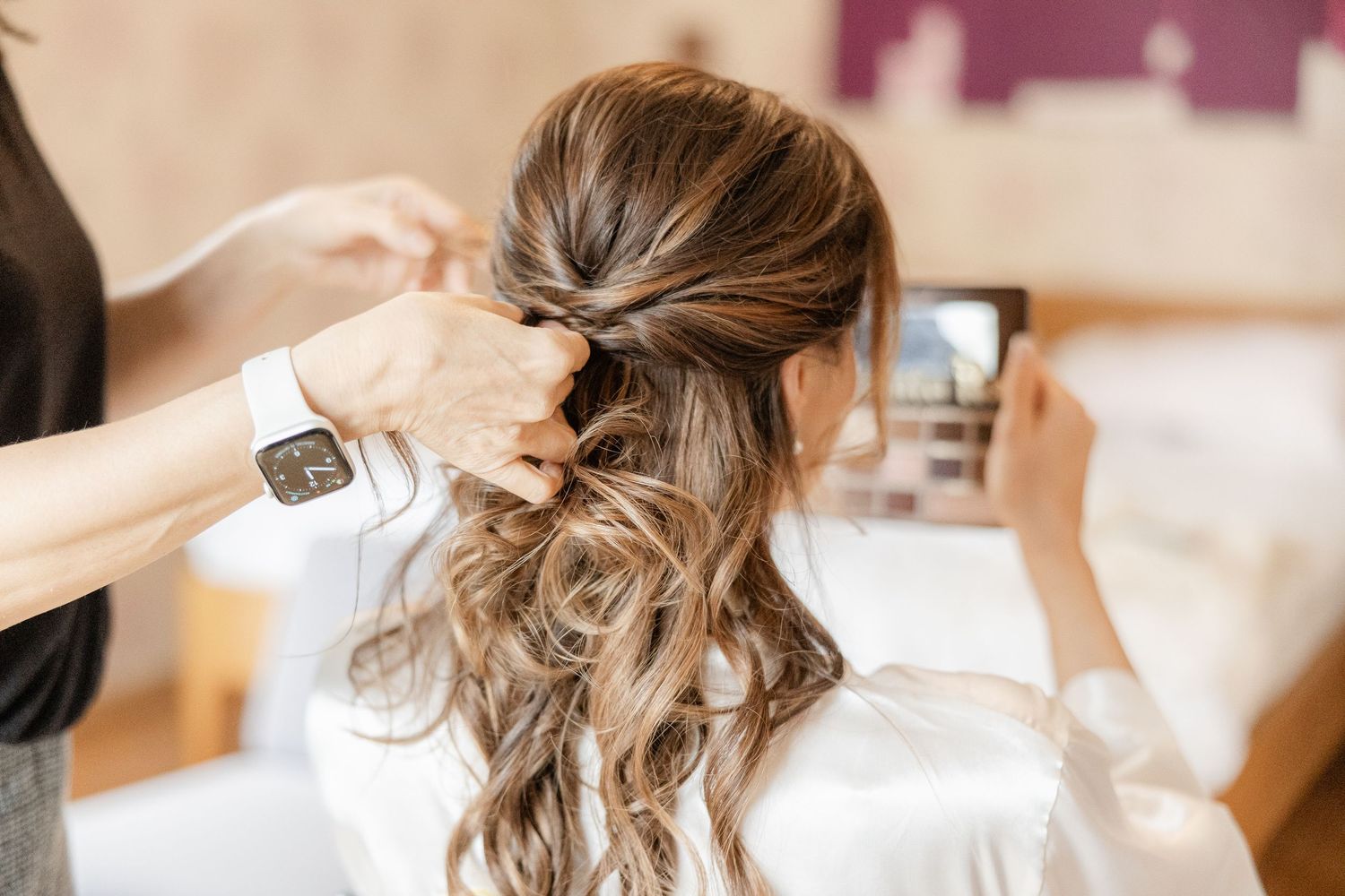 Professional hairstylist creates an elegant updo hairstyle for a formal event or wedding.