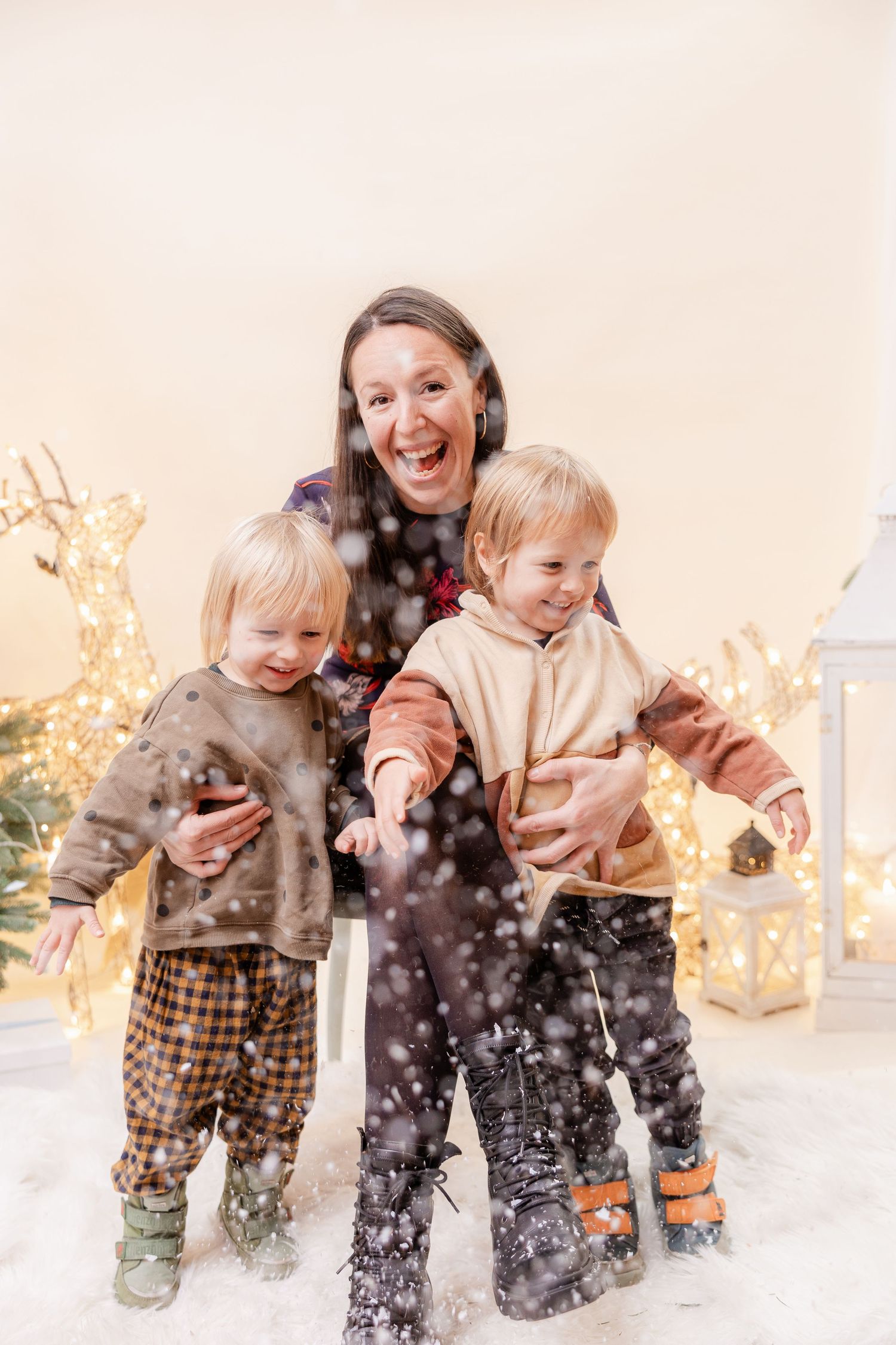 A joyful winter scene with people playing and throwing snow in the air during golden hour.