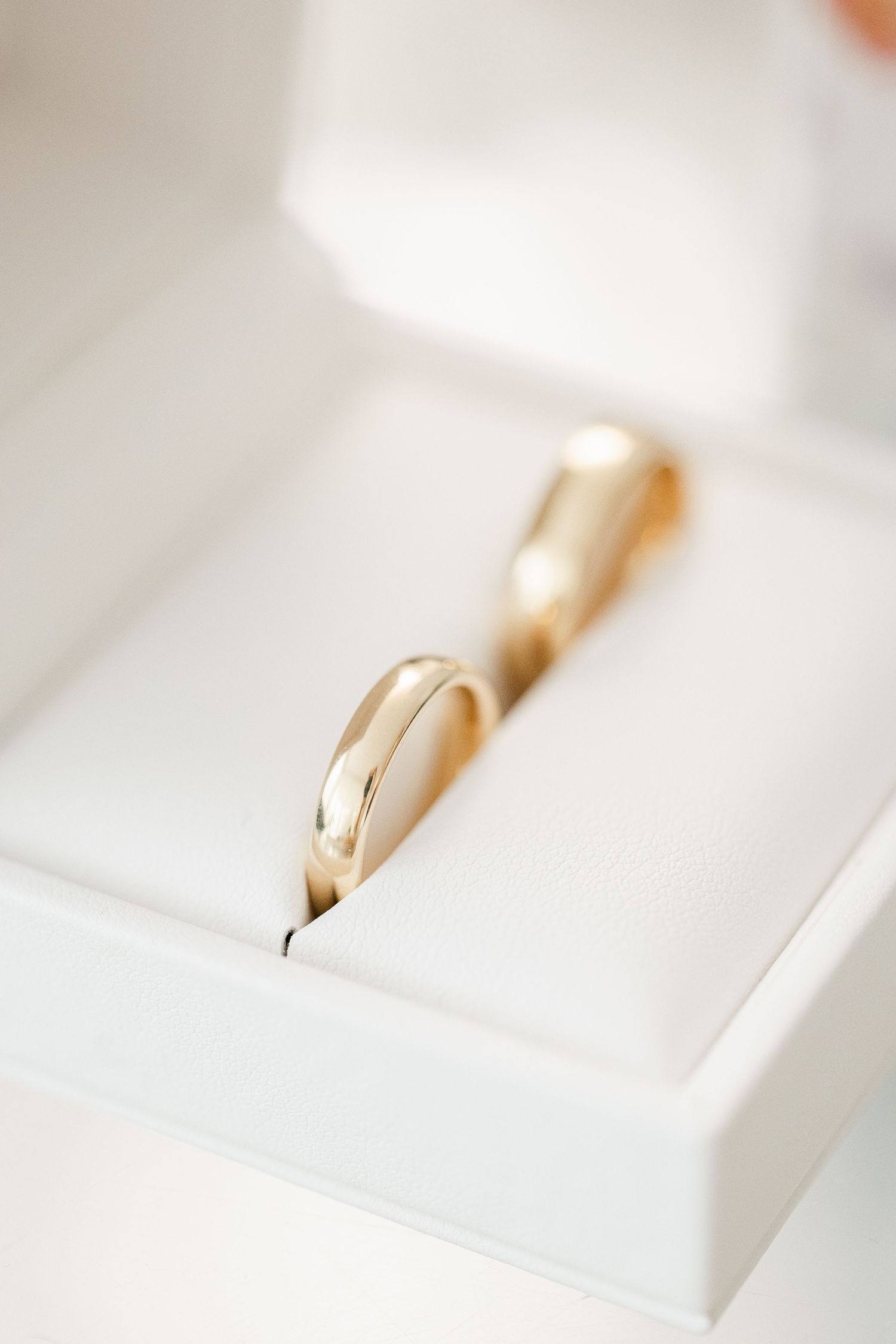 A close-up sequence of gold wedding rings on a white surface showing different angles and perspectives.