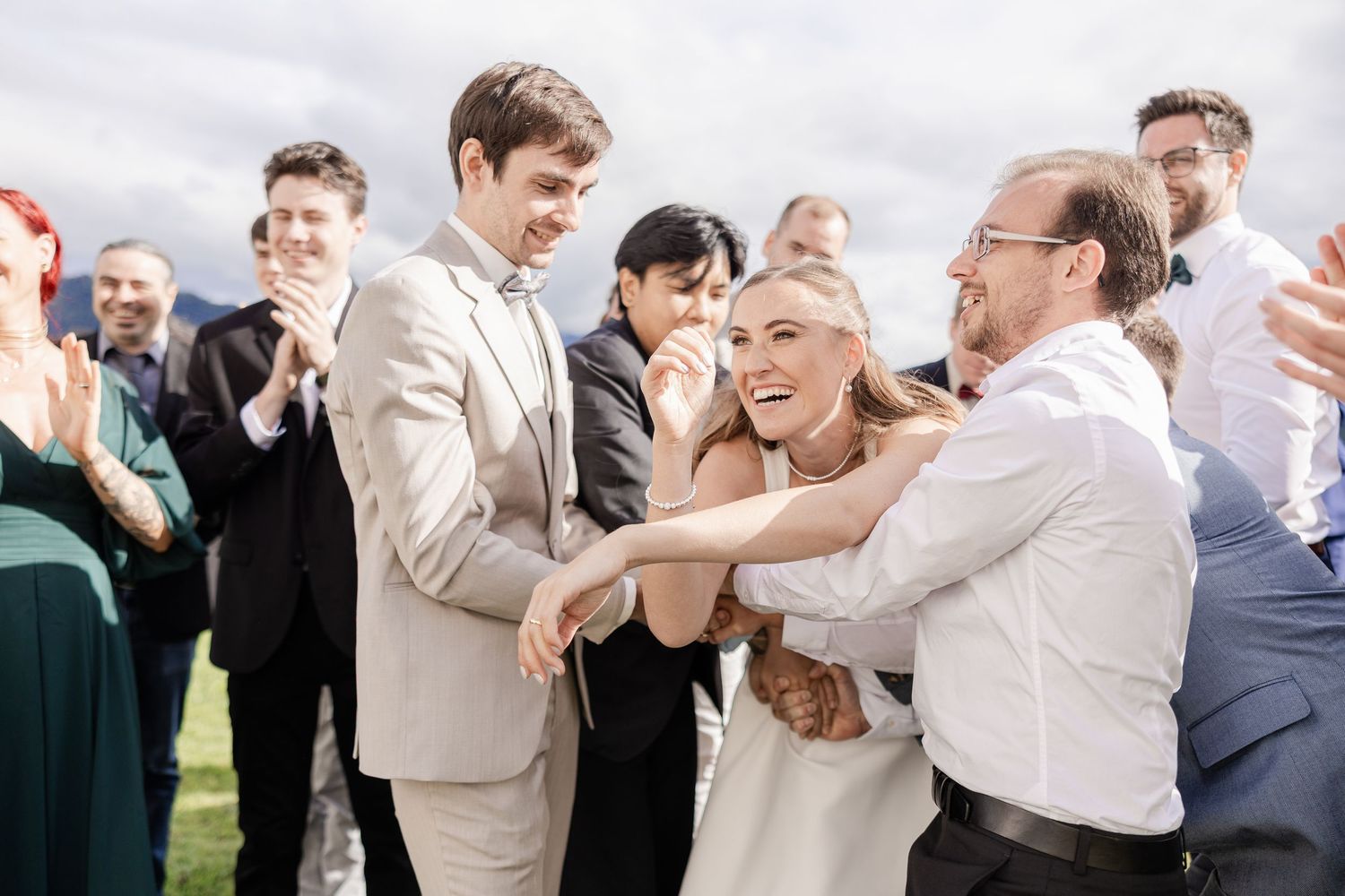 Group of wedding guests dancing and celebrating together on a dance floor during a reception.