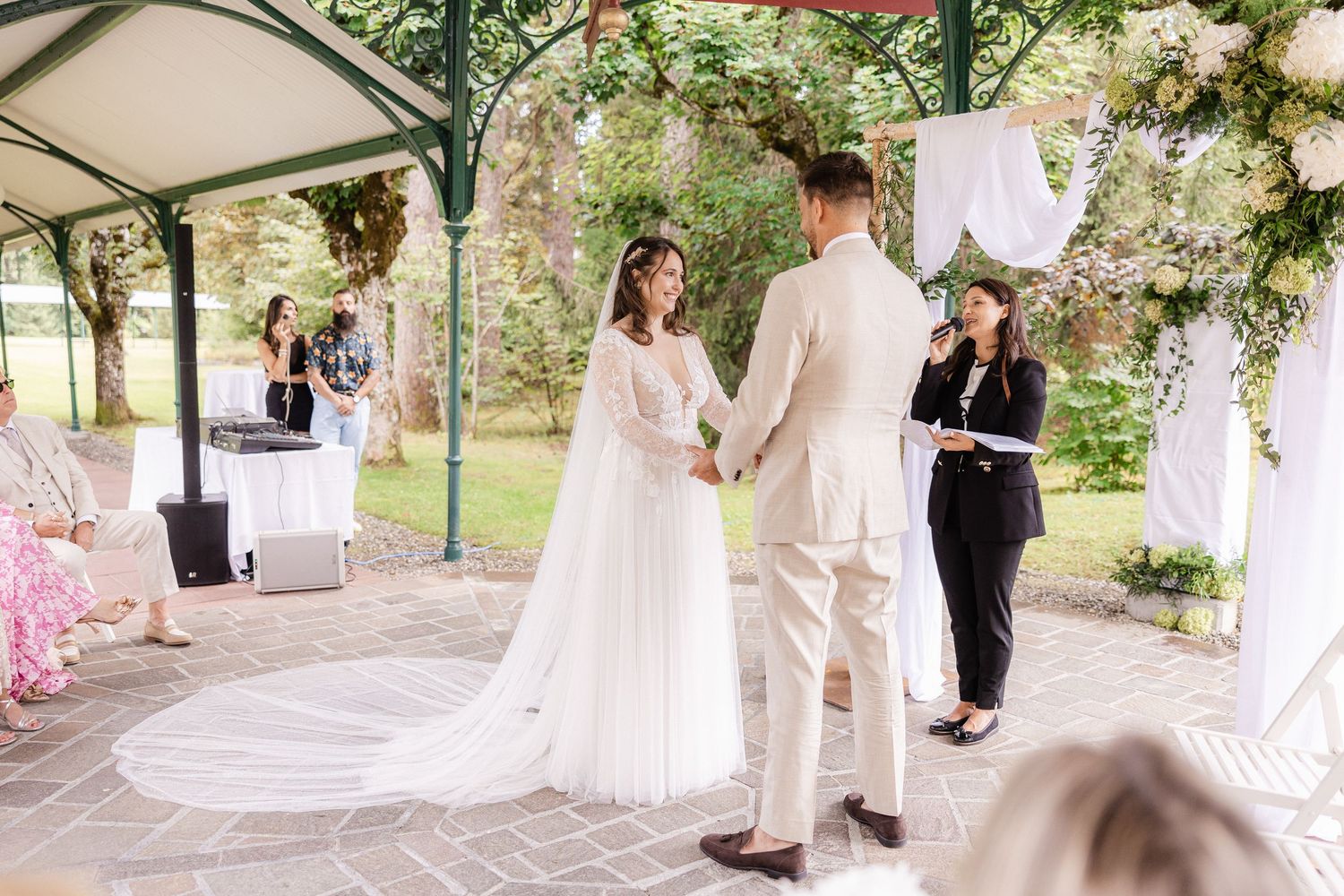 A series of wedding ceremony moments captured under a white outdoor tent decorated with floral arrangements.