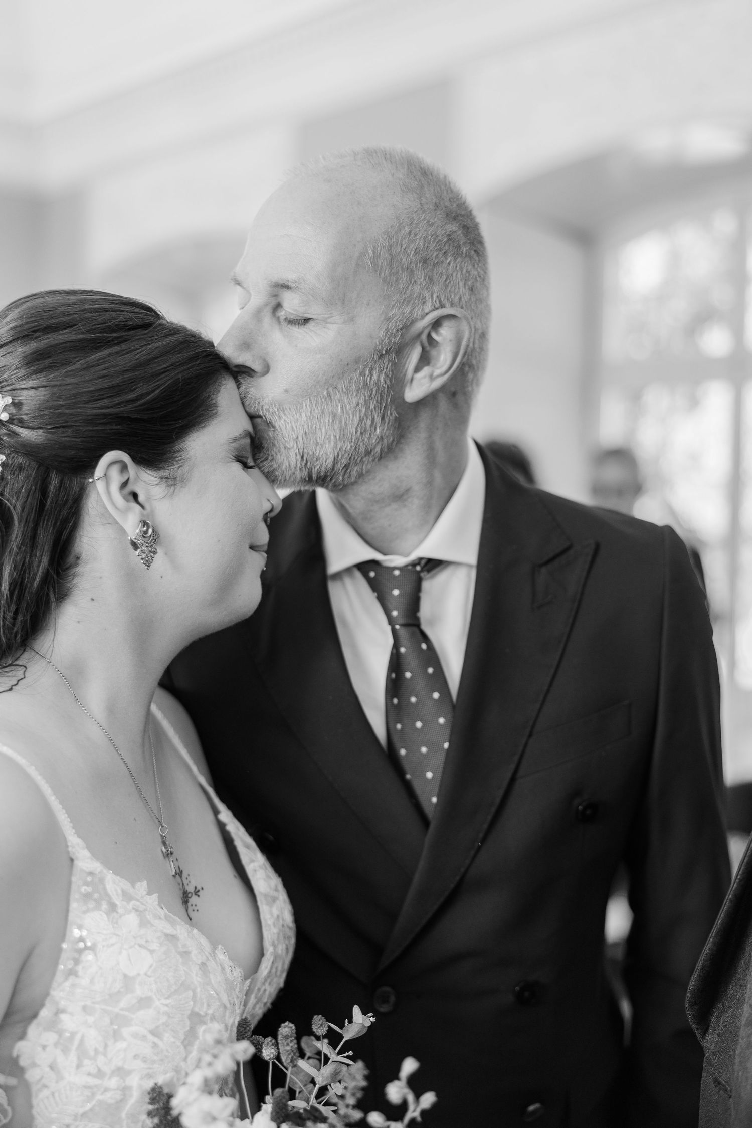 A series of romantic wedding day kisses between a couple, with the bride wearing a white lace dress.