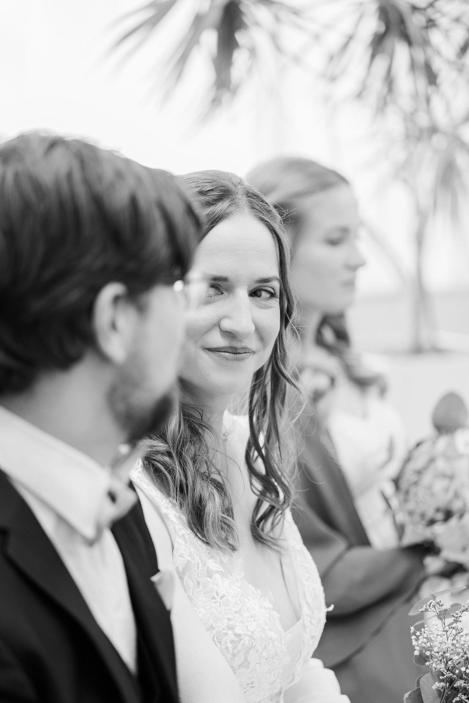 Black and white close-up photos of a bride and groom sharing intimate moments during their wedding celebration.