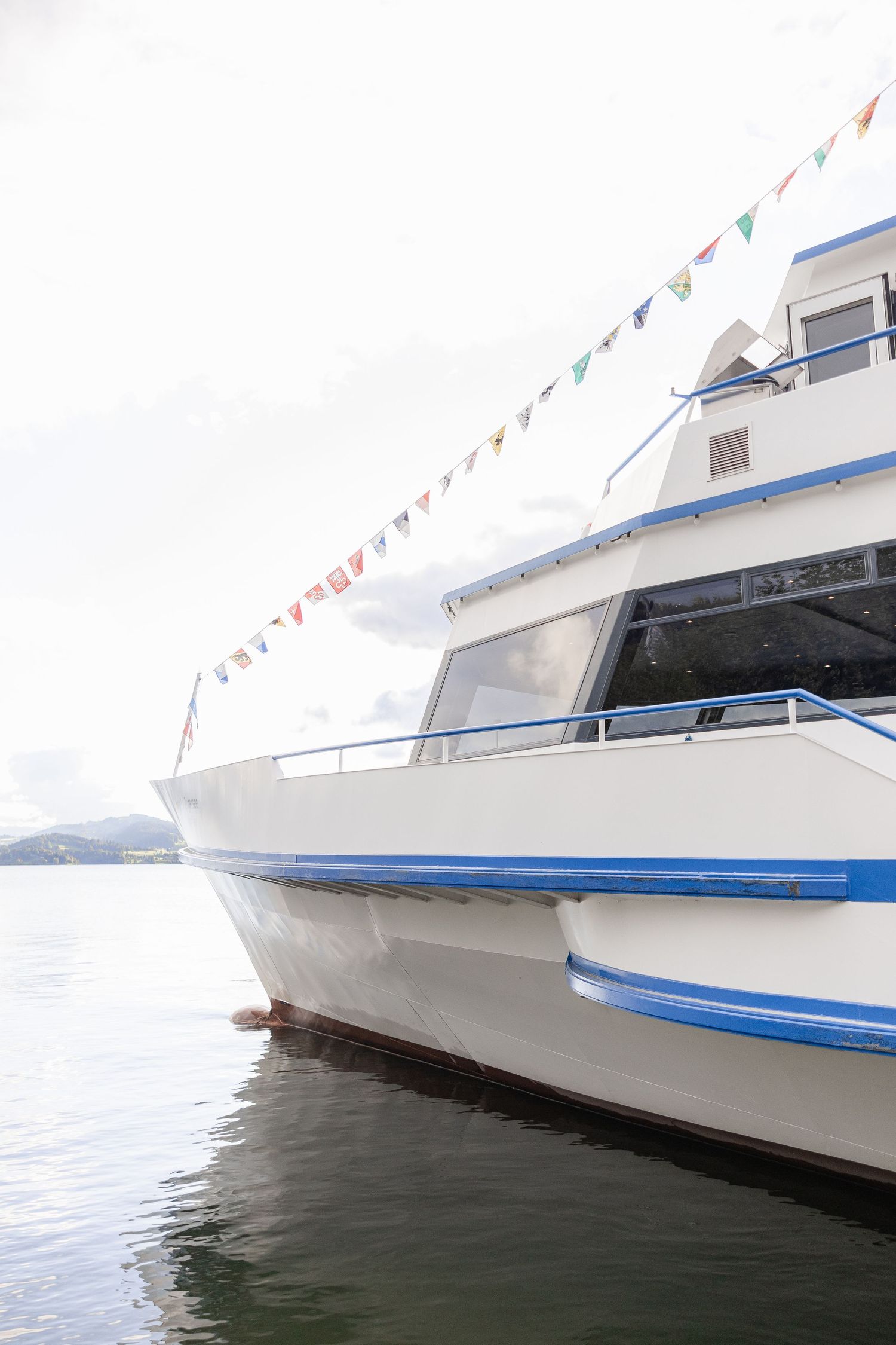 Close-up views of a white yacht's hull with blue trim details showing different angles at the waterline.