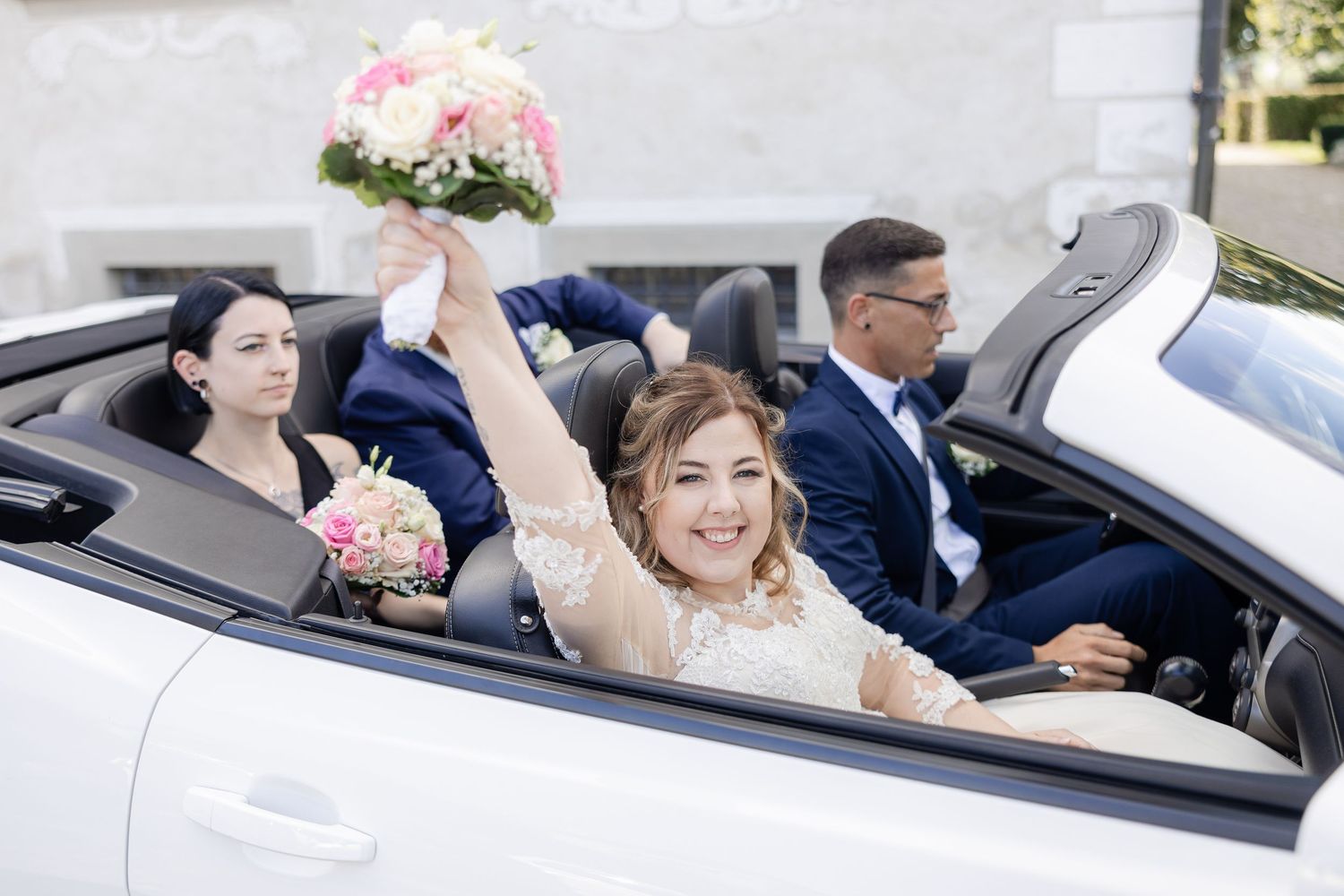 Five connected photos show a couple celebrating in a convertible car with pink rose bouquets and wedding attire.