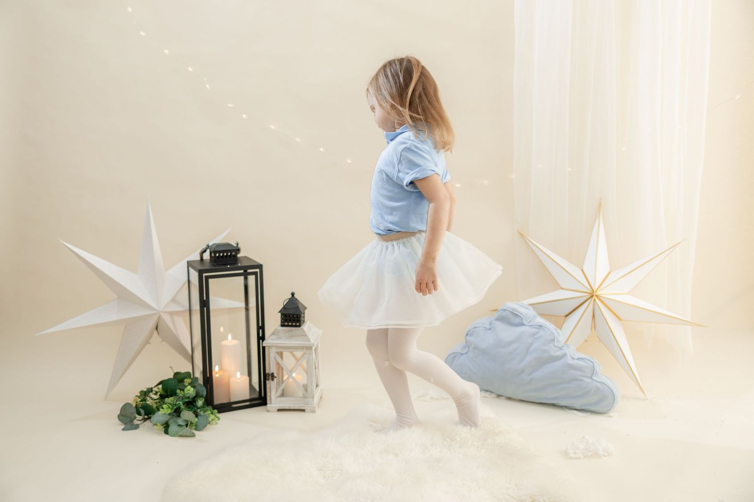 White paper stars and lanterns create a dreamy holiday scene against a light neutral backdrop.
