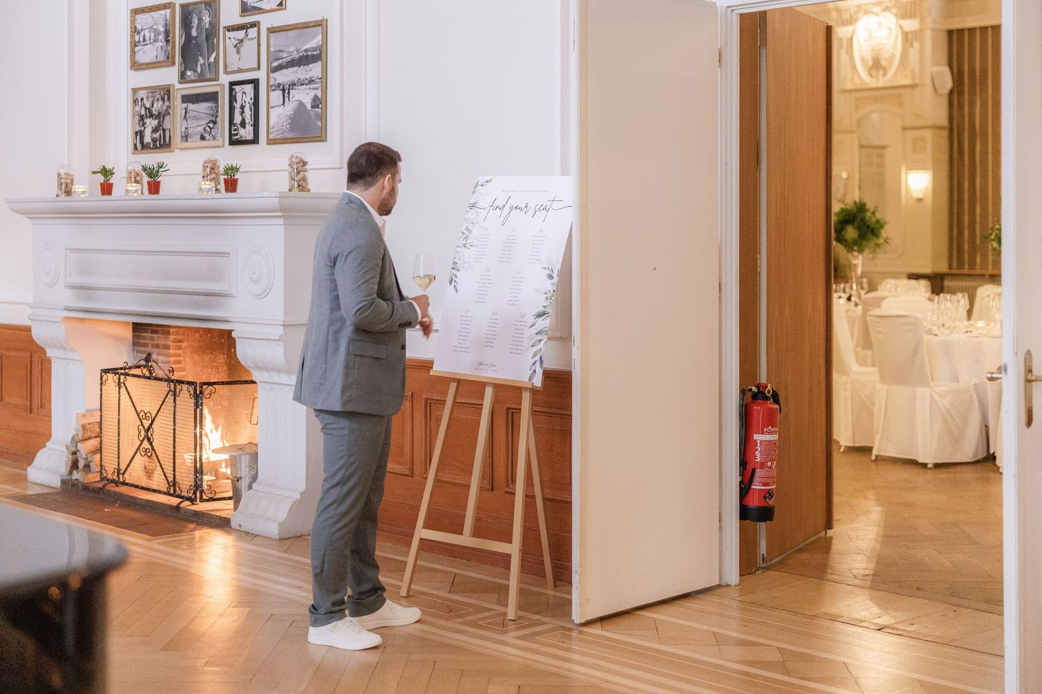 A wedding venue interior with white walls, hardwood floors, and framed photos displaying a bright, elegant atmosphere.