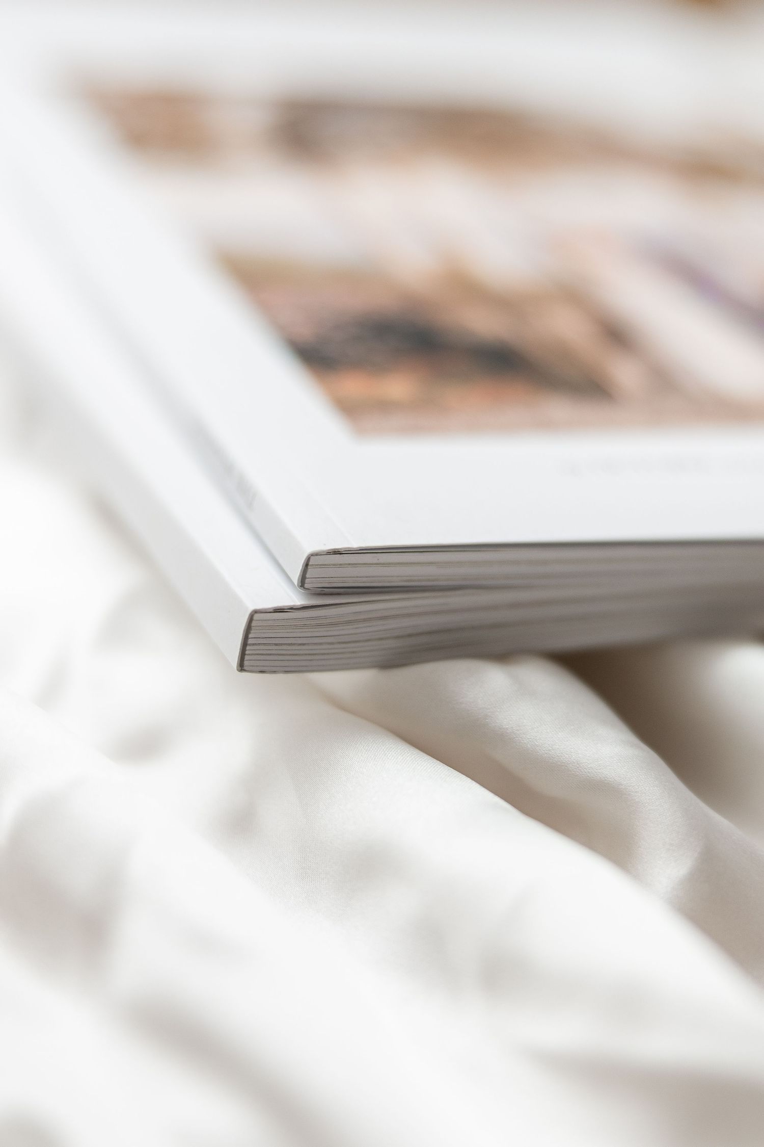 Macro shot of white paper pages stacked together with shallow depth of field creating abstract lines and texture.