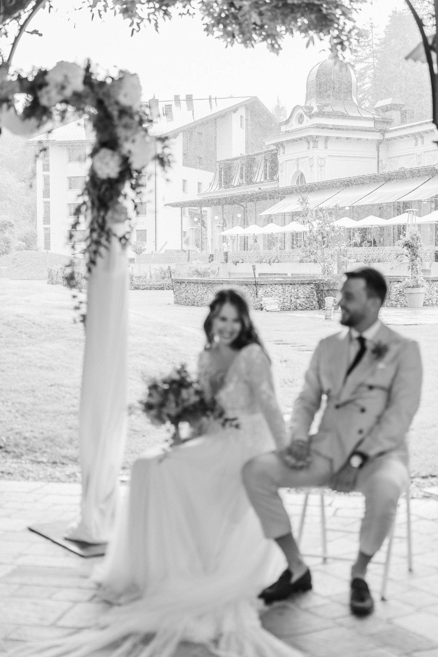 A black and white photo series shows a couple sitting together on a porch swing in romantic poses.