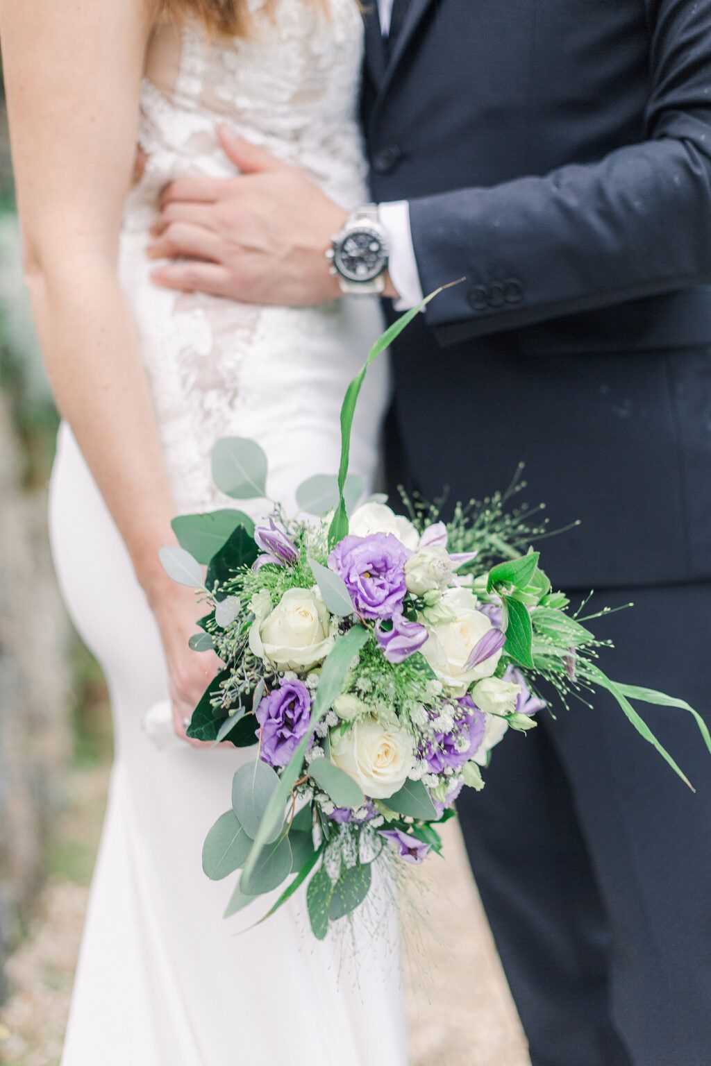Close-up views of purple and white wedding bouquets held against a black suit and white dress in four similar poses.