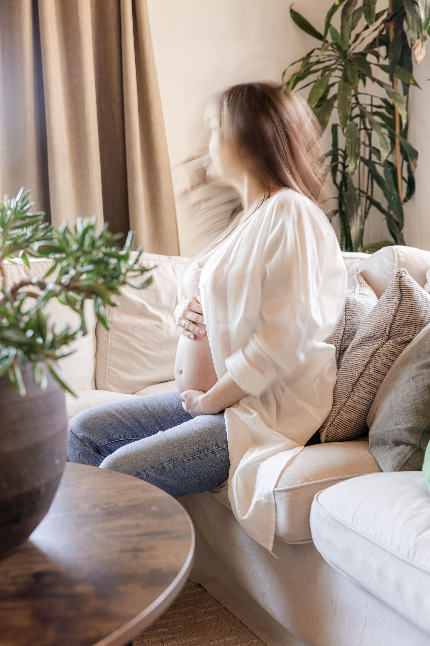 A series of photos showing someone in a white shirt and jeans sitting casually on a beige couch near indoor plants - Fotograf Zuhause Aargau