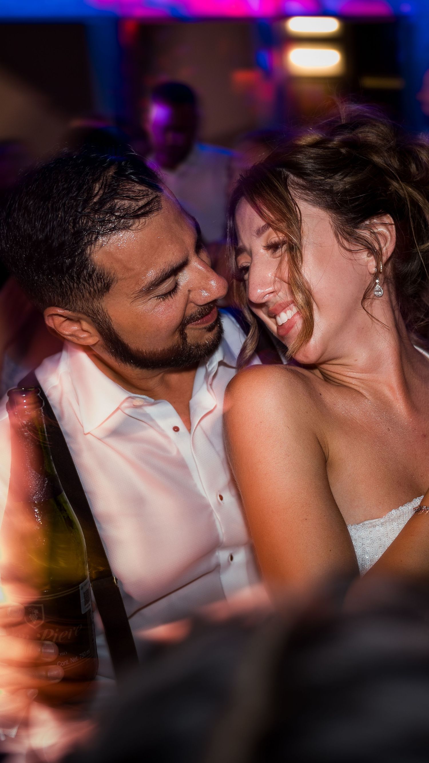 Happy bride and groom sharing an intimate romantic moment at their wedding reception.