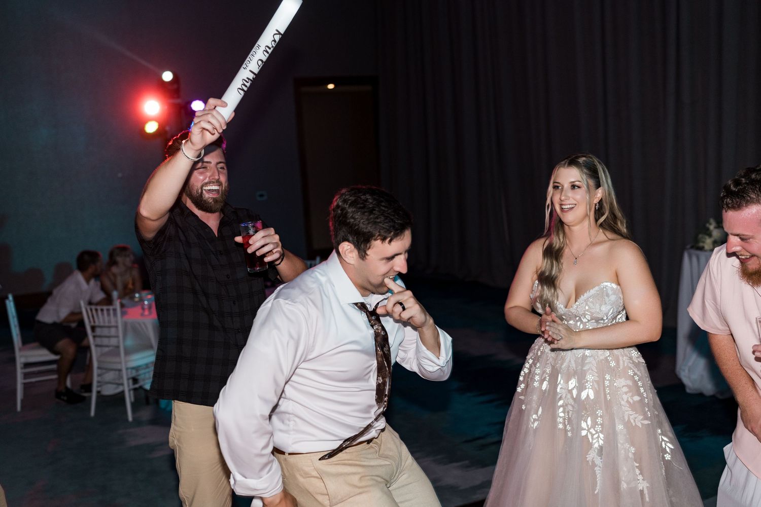 Guests dancing and celebrating at a lively wedding reception on the dance floor.