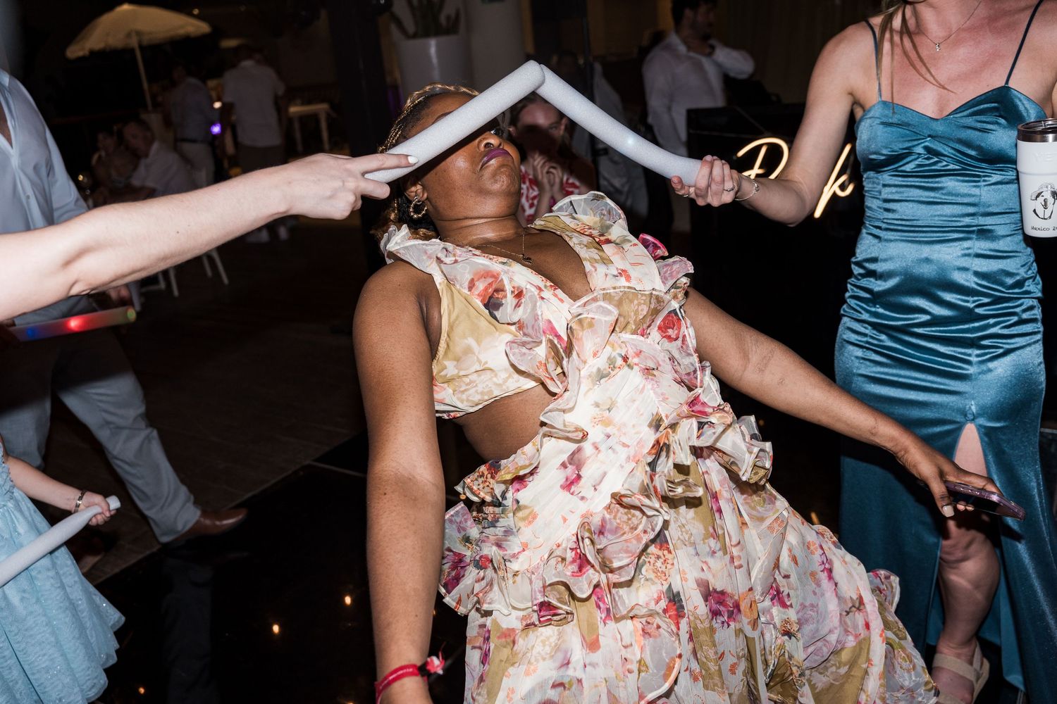 Woman in floral dress dancing at a wedding reception party celebration.