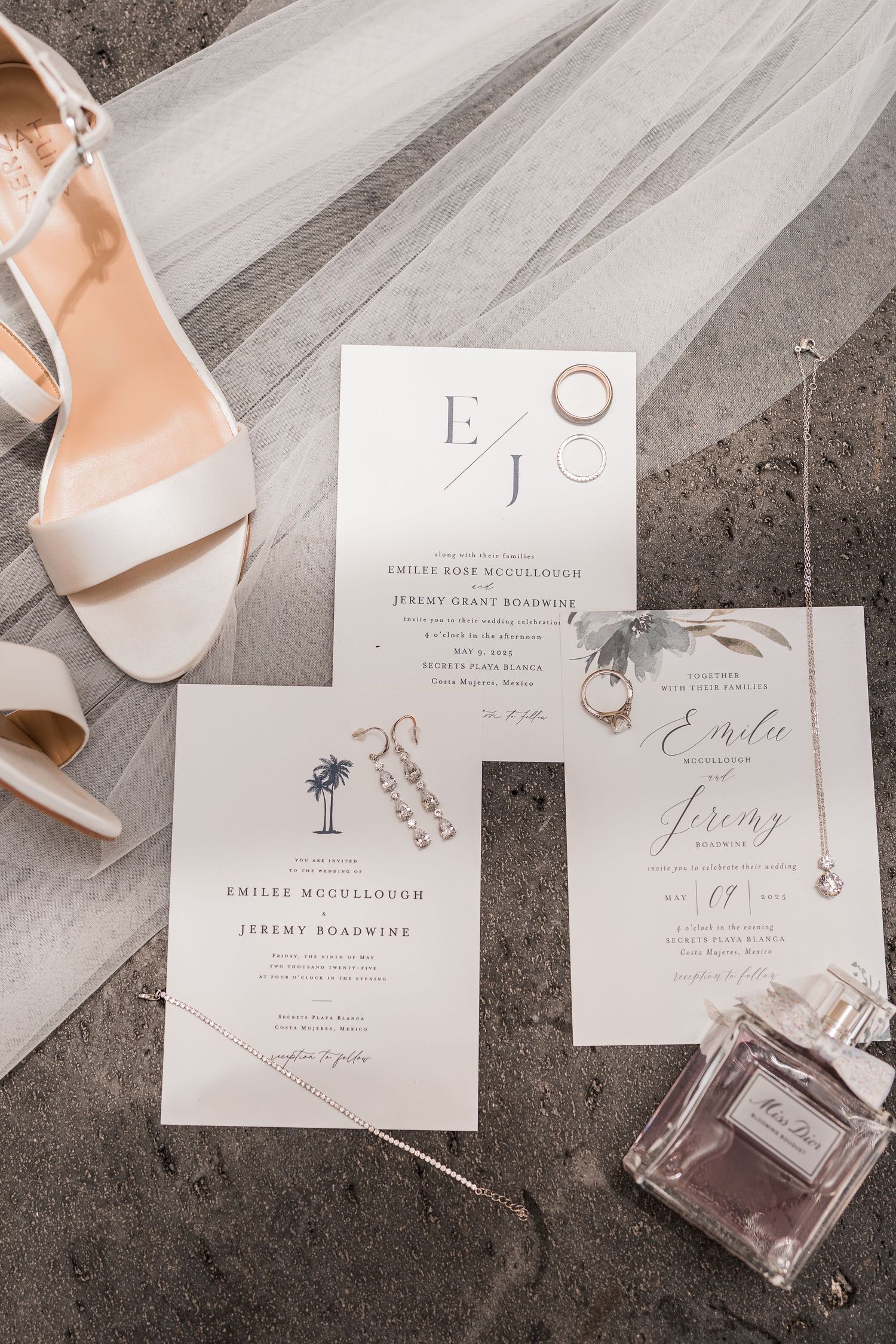 Elegant wedding flat lay with ivory heels, floral invitations, gold rings,  and Dior perfume on gray surface. Playa del carmen wedding