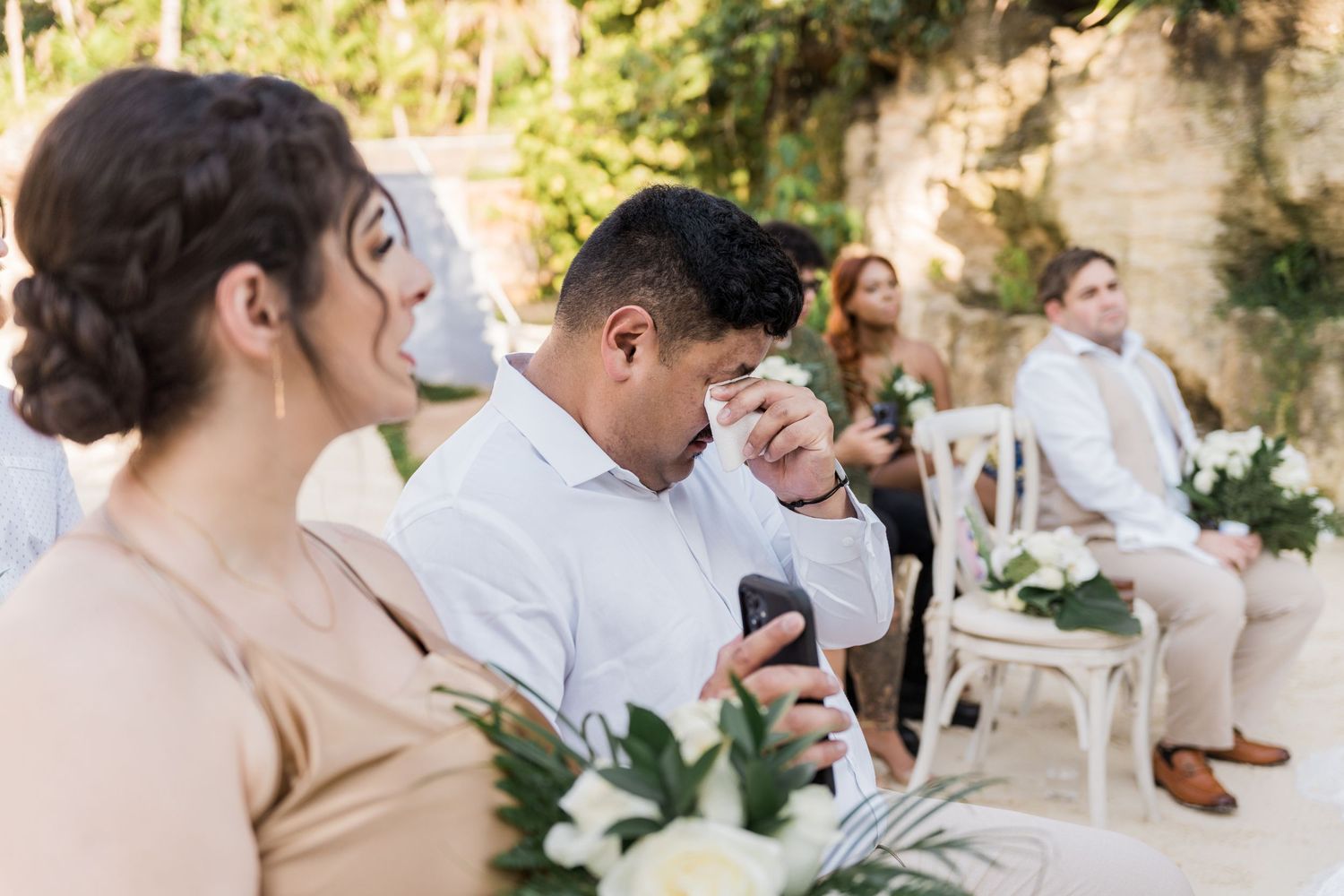 Xcaret Arte Wedding - Emotional wedding guest wiping tears during outdoor ceremony,