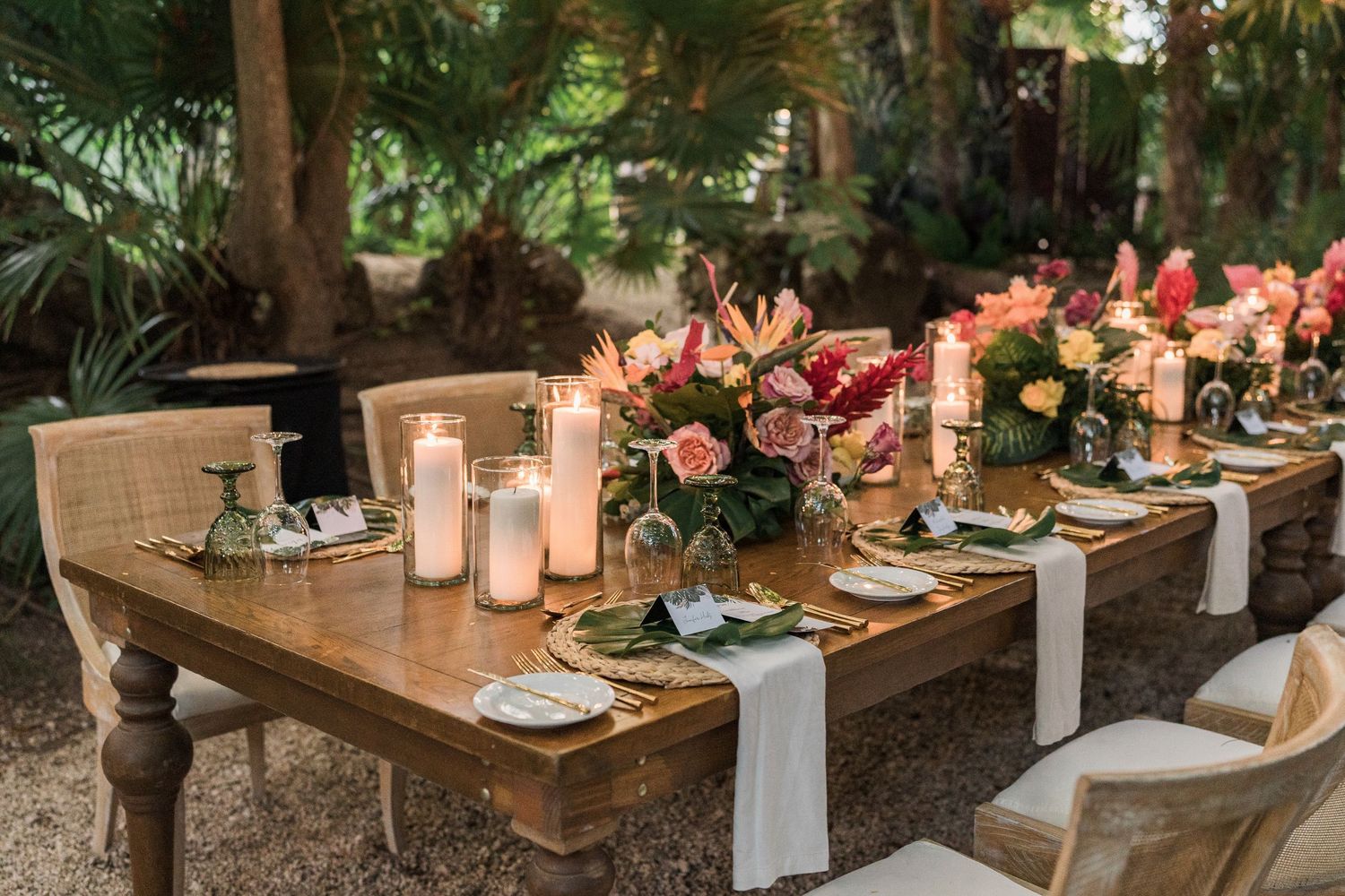 Secrets Akumal Wedding - Elegant outdoor farm table wedding reception with candles, tropical floral centerpieces, gold accents.