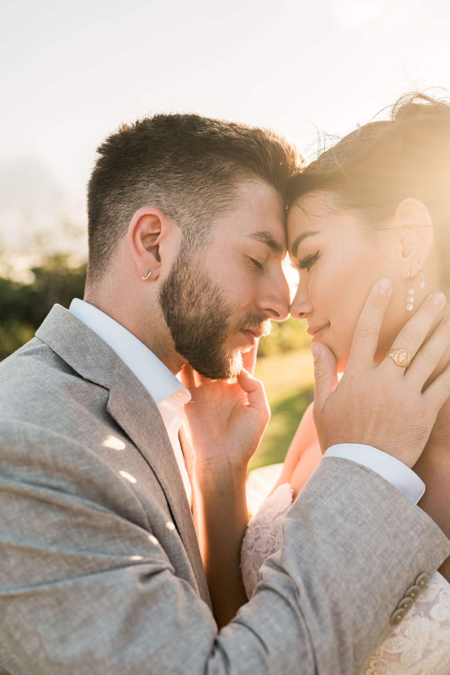 A bride and groom share an intimate forehead-to-forehead moment bathed in warm golden sunset light. Puerto Vallarta wedding photographer