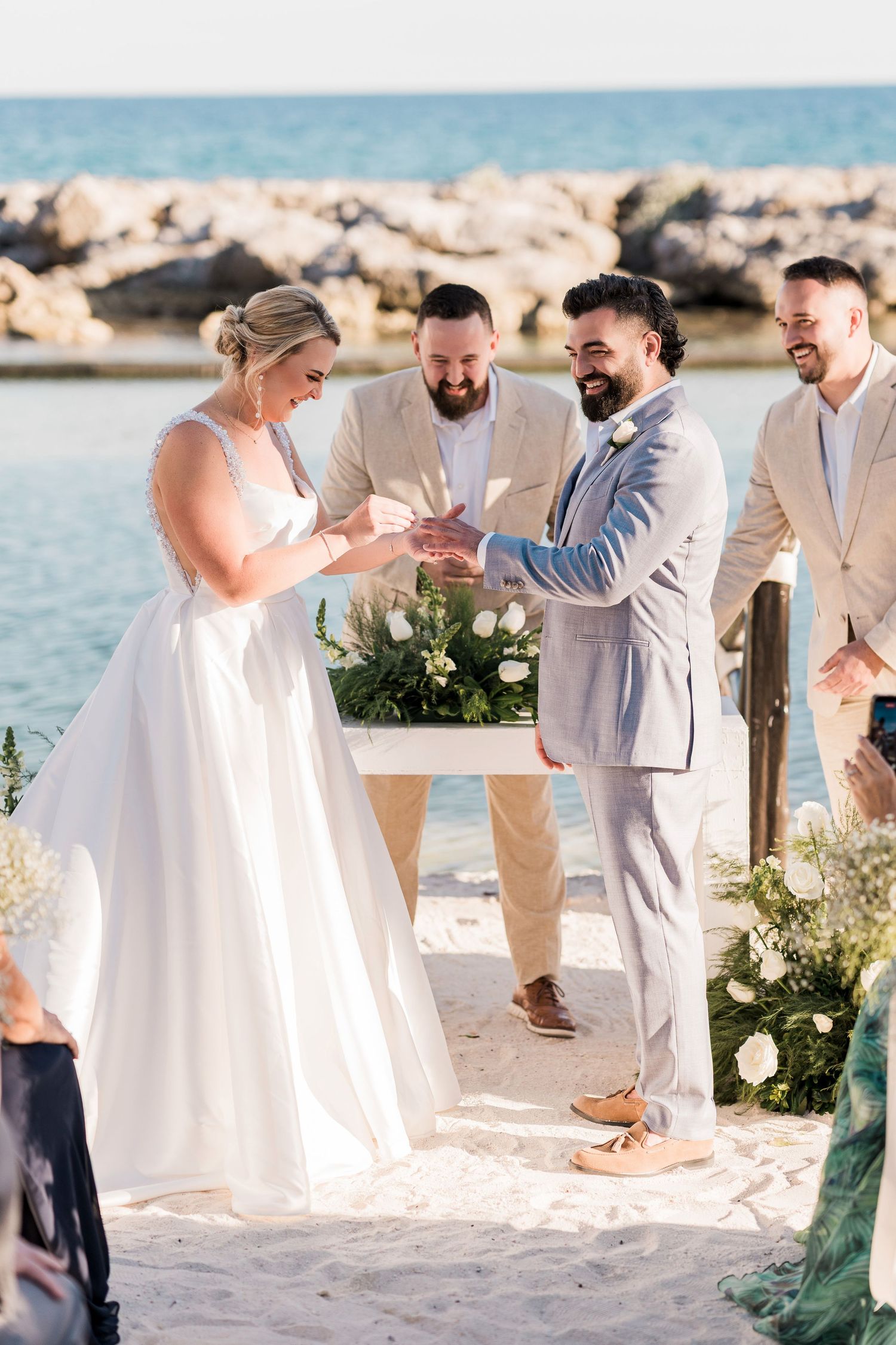Bride and groom exchange rings at a romantic beachside wedding ceremony at Hard Rock Riviera Maya