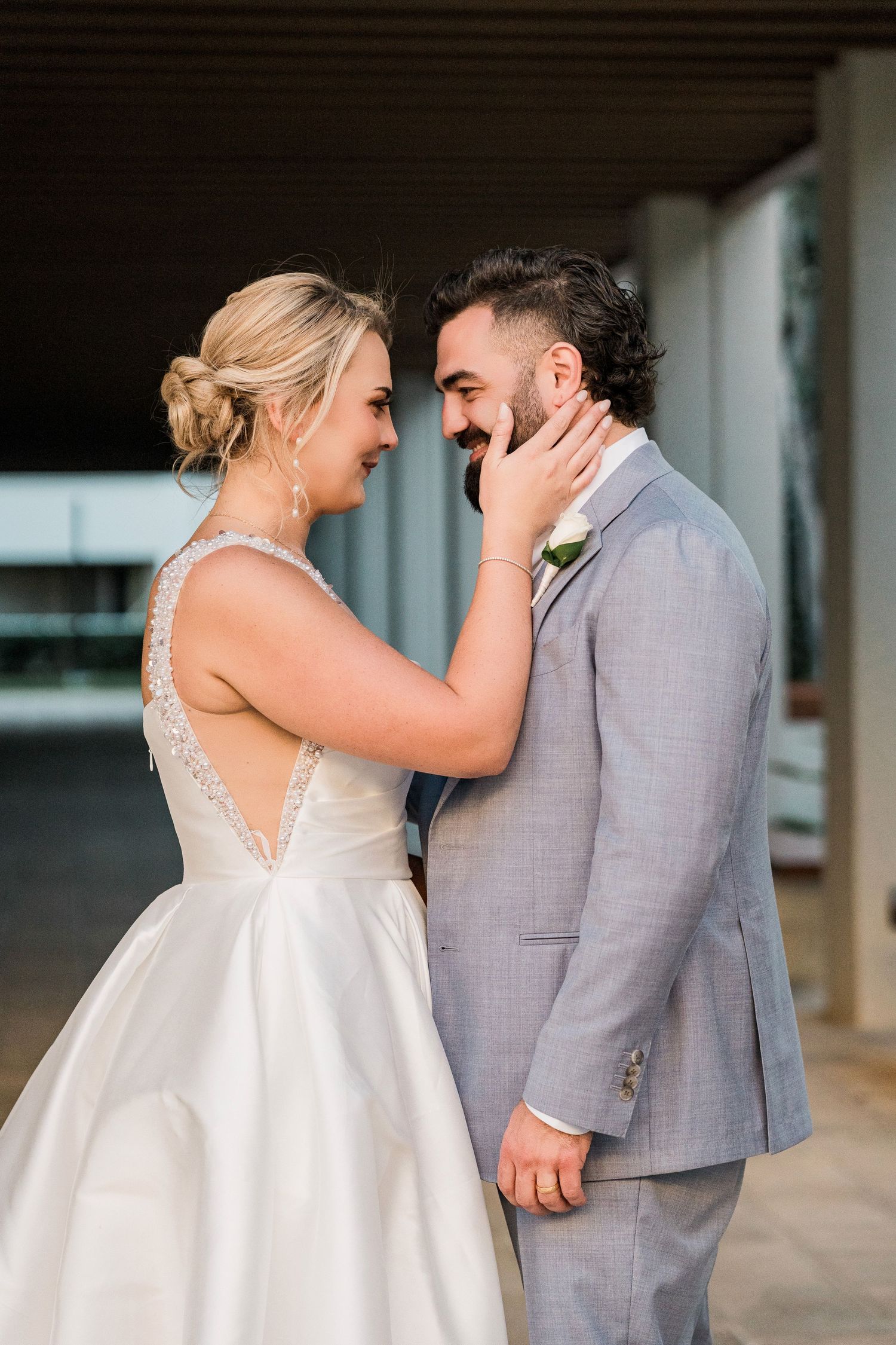 Bride in white gown tenderly touches groom's face as they share an intimate moment, Hard Rock Riviera Maya wedding photographer