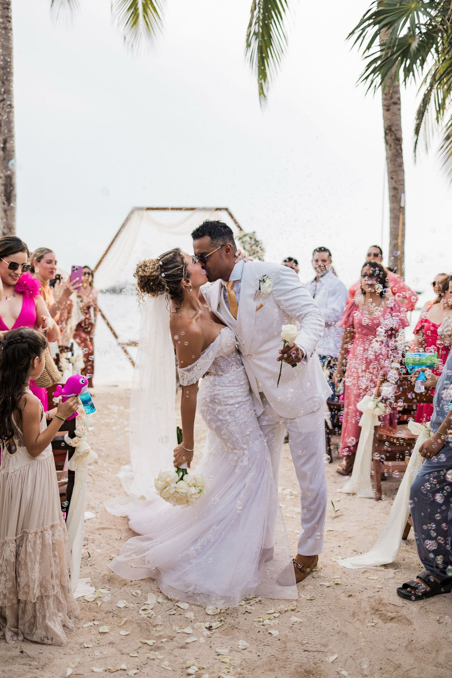 Bride and groom share a first kiss on a sandy beach wedding ceremony. Puerto Vallarta wedding photographer