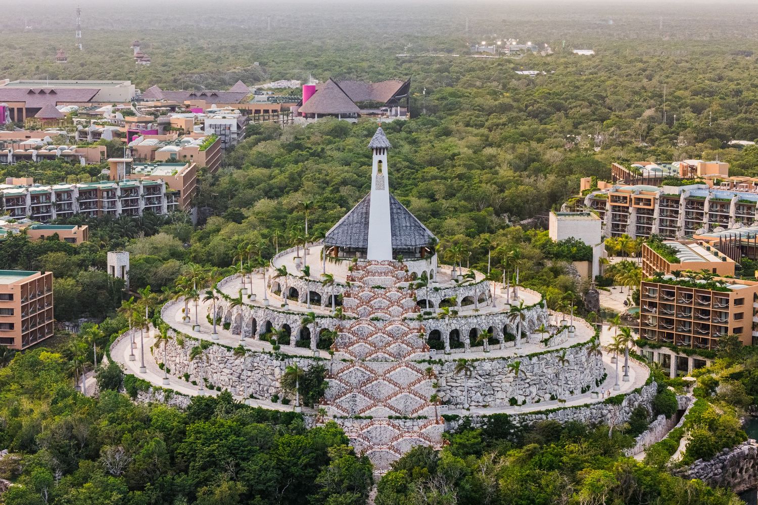 Hotel Xcaret México Wedding  - Aerial view of a grand circular monument surrounded by lush greenery and resort buildings
