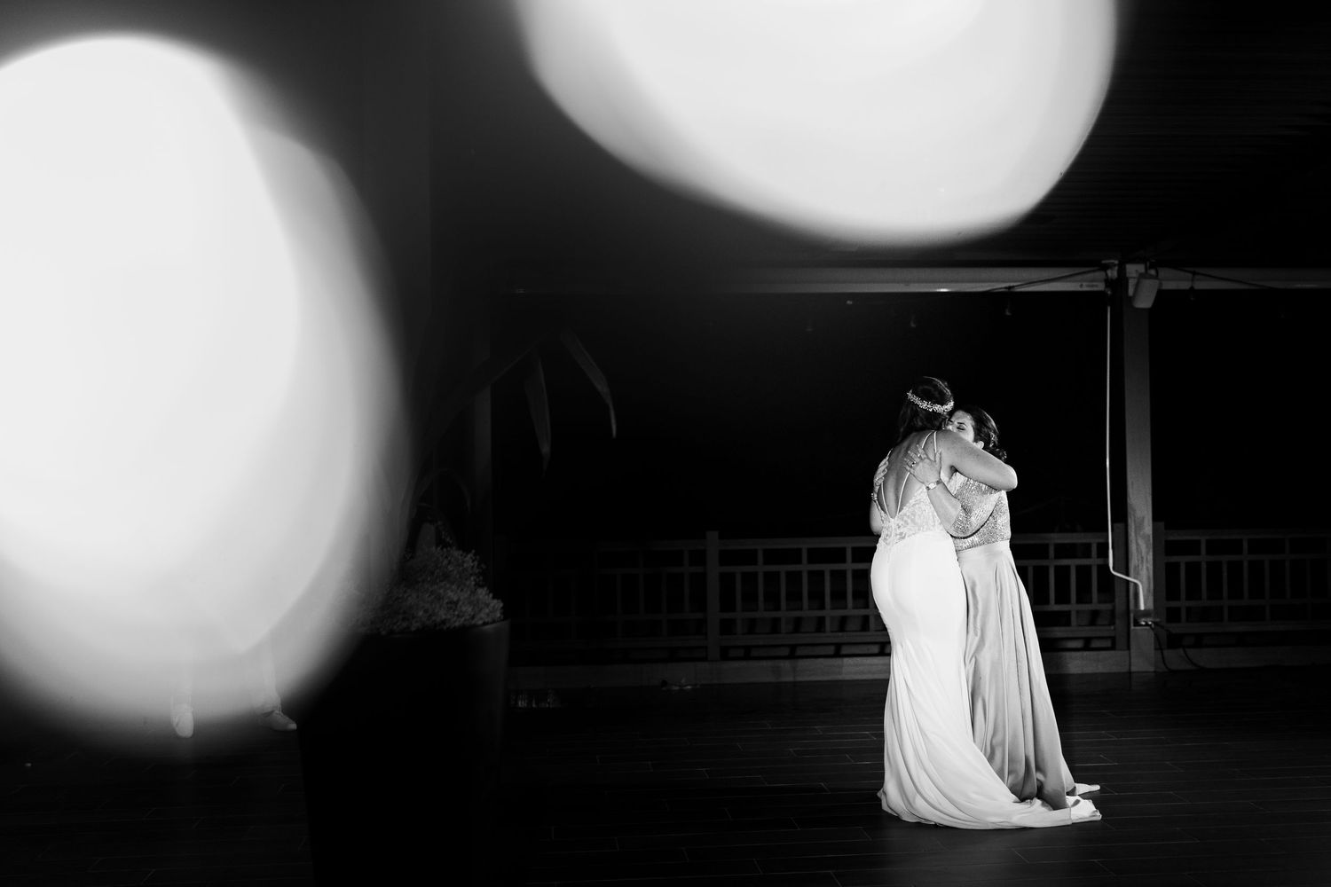 Black and white artistic photo of bride and mother sharing a tender dance at wedding reception.